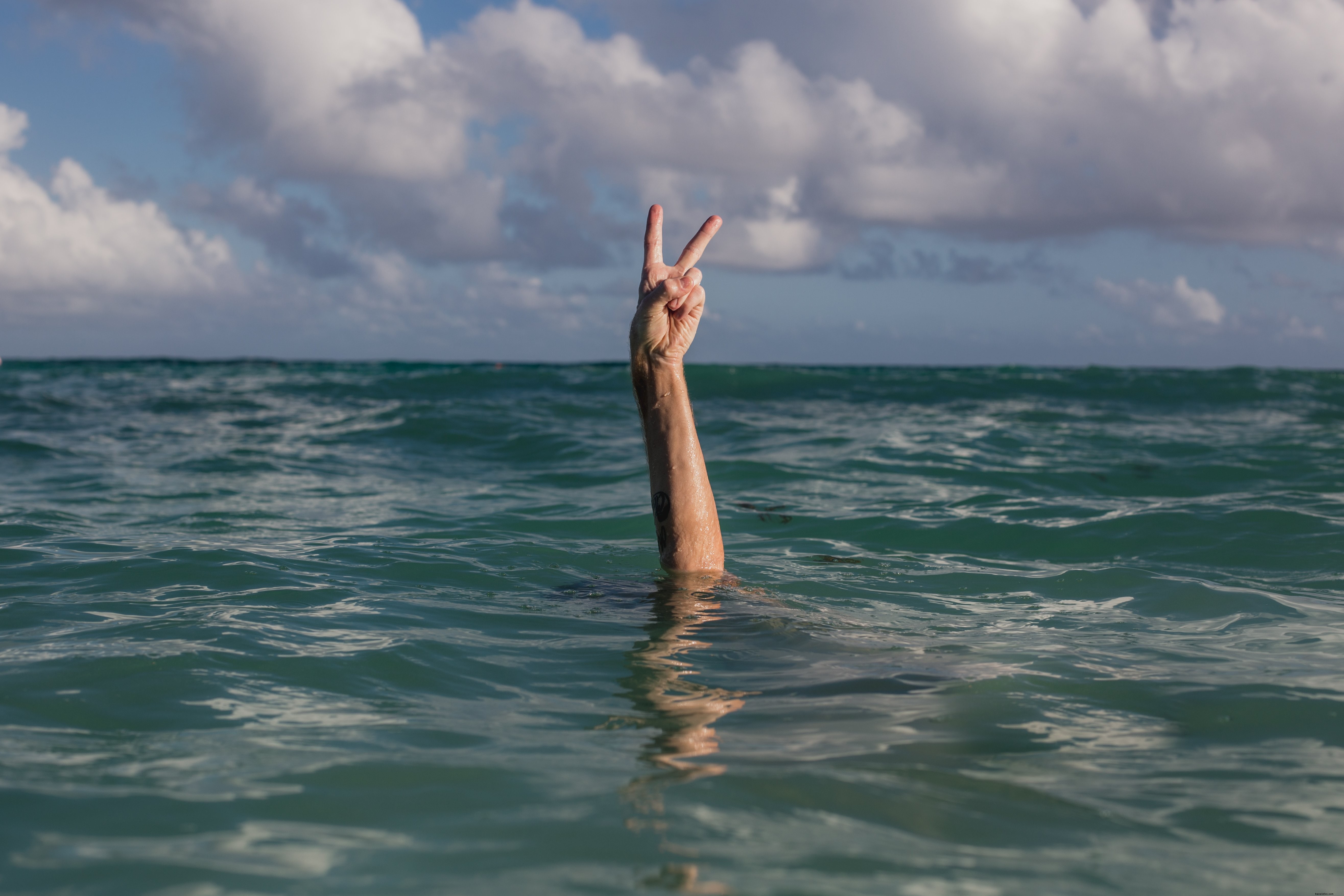 Serene Hands Forming Peace Sign in Crystal Clear Water – Stunning Photo