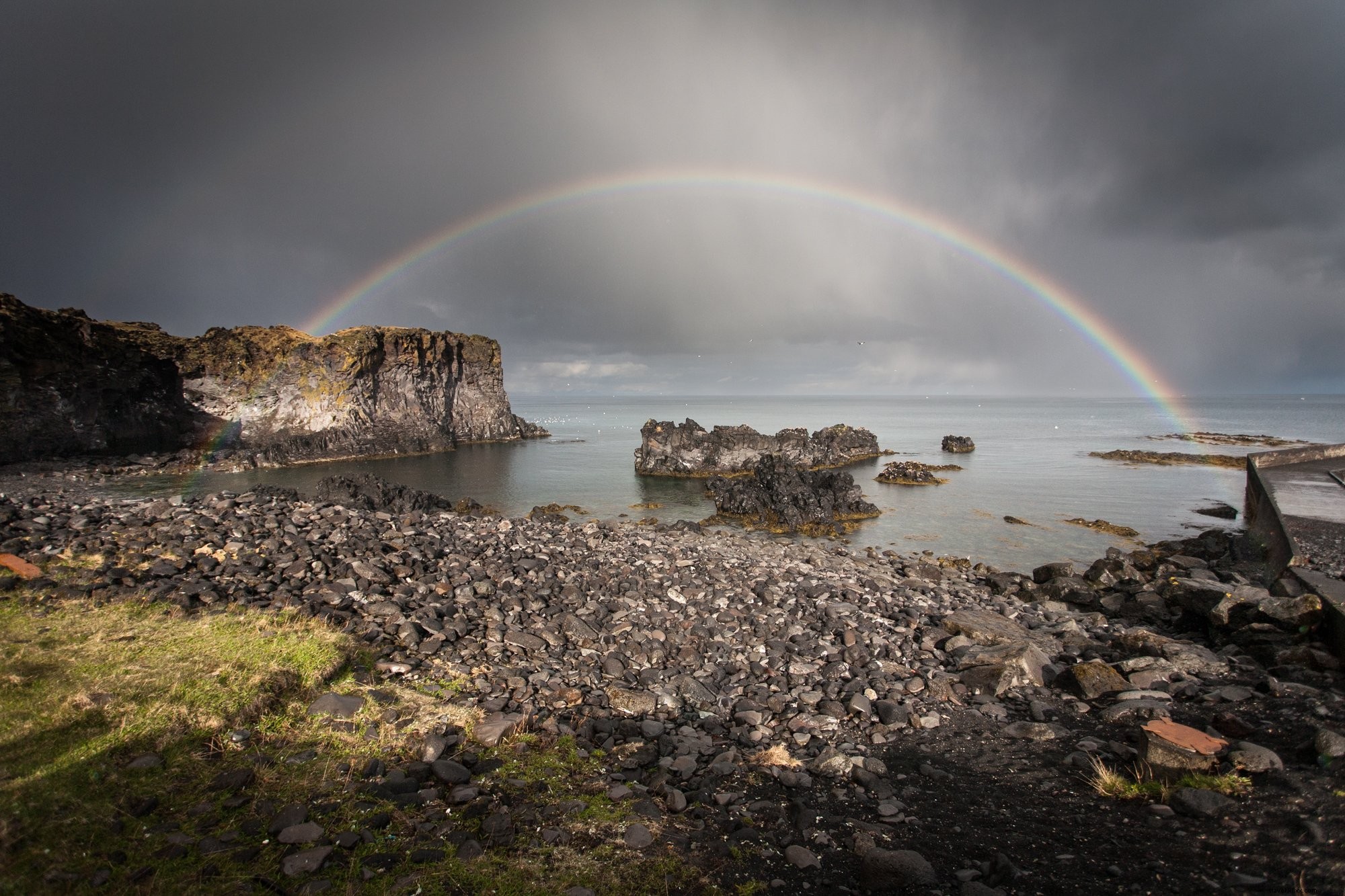 Stunning Full Rainbow Arcing Over Rocky Waters – Breathtaking Nature Photo