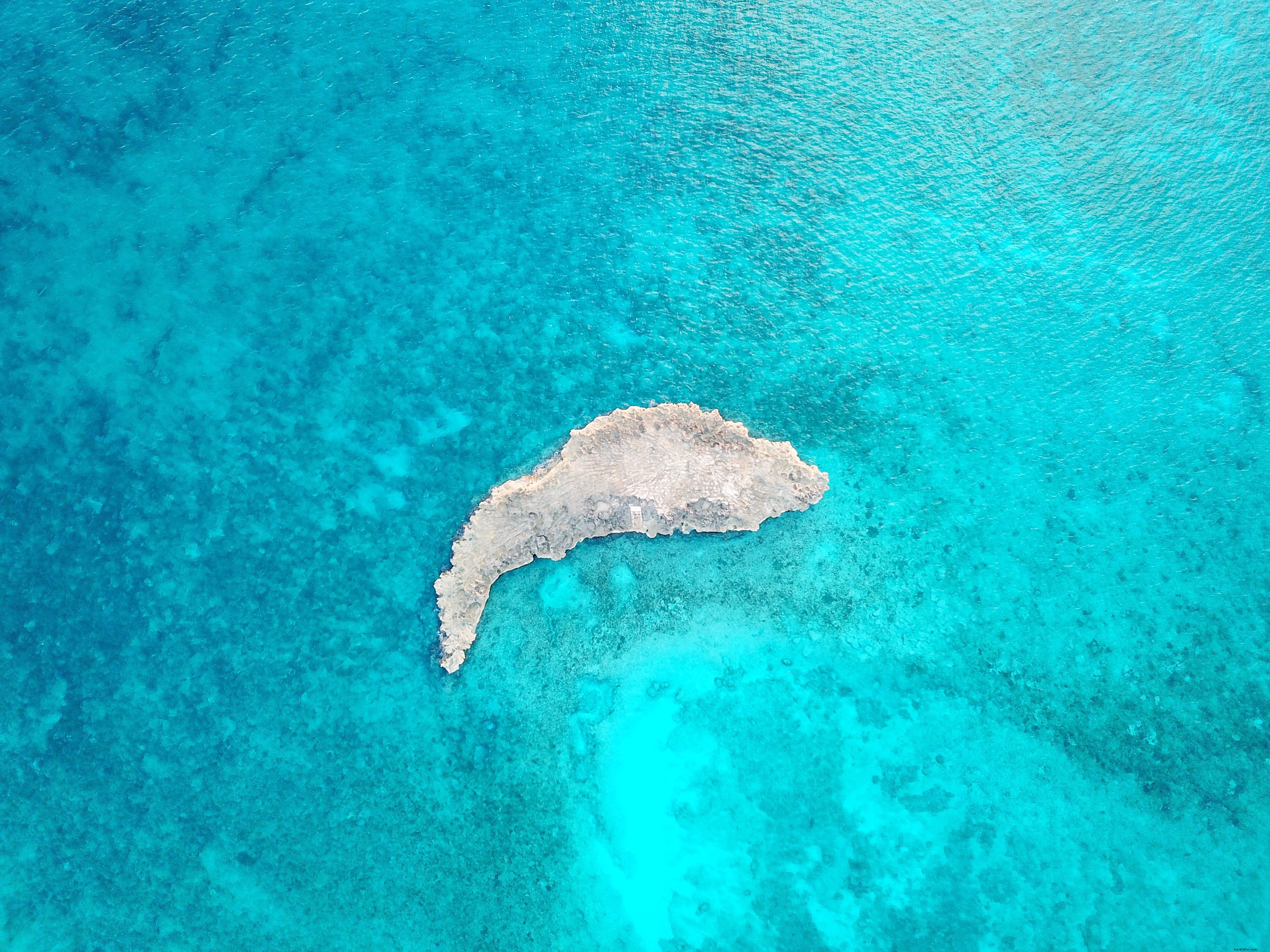 Stunning Photo: Small Rocky Island in Crystal-Clear Ocean Shallows