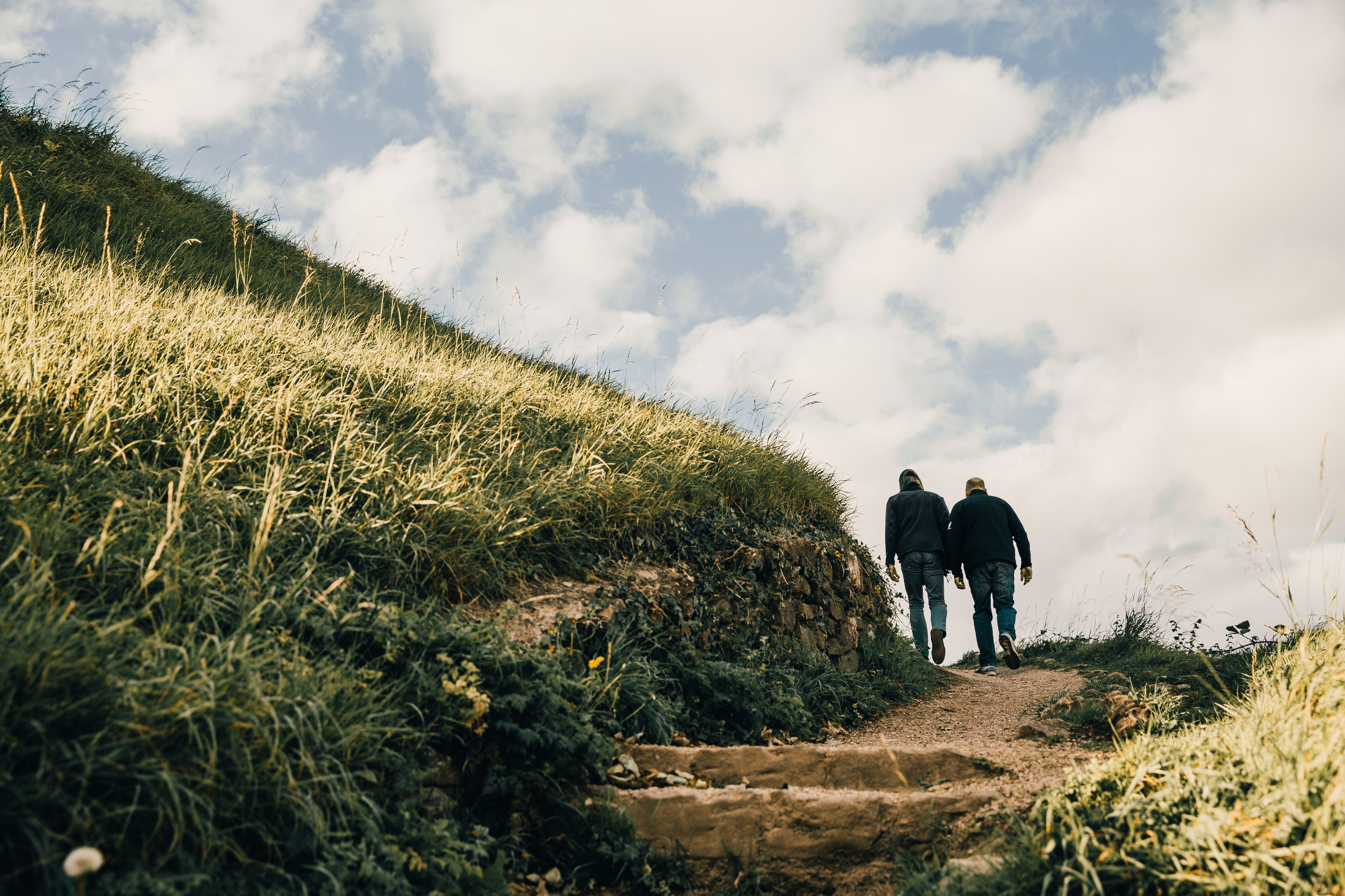 Stunning Photo of Adventurous Men Hiking Lush Grassy Hills