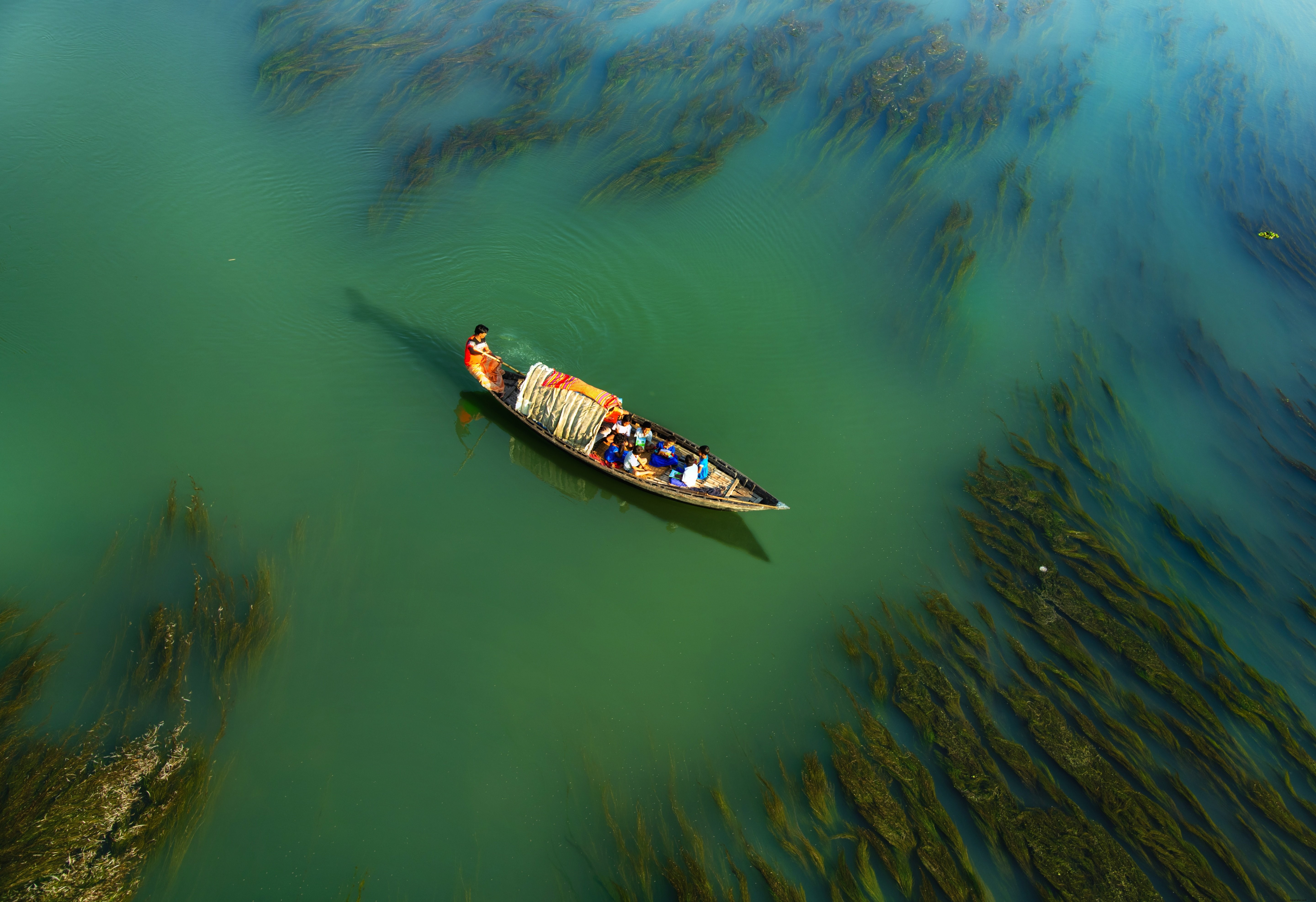 Stunning Photo: Travelers on a Small Boat Crossing Serene Waters