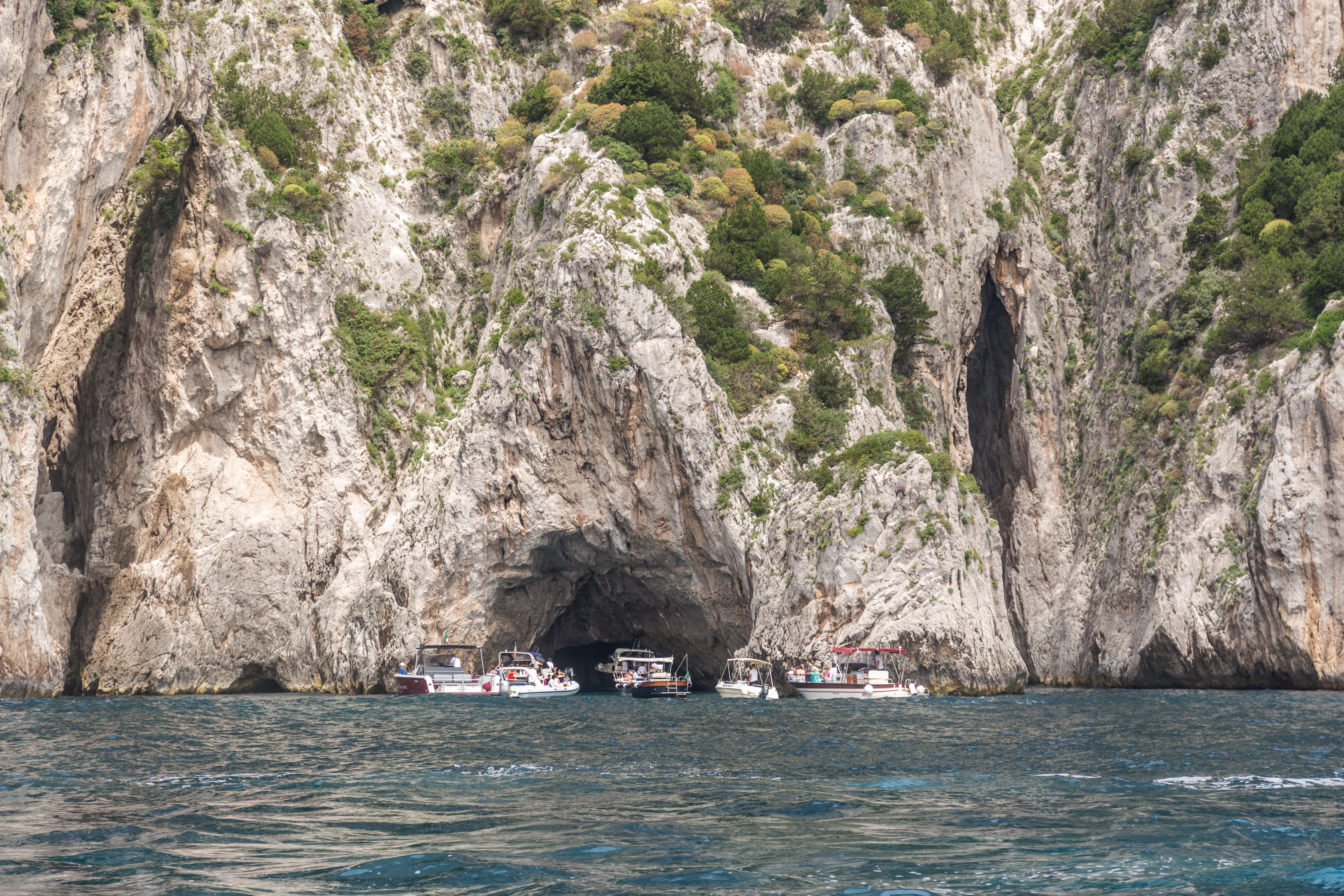 Stunning Seascape: Boats Gathered in Front of Majestic Cave Photo