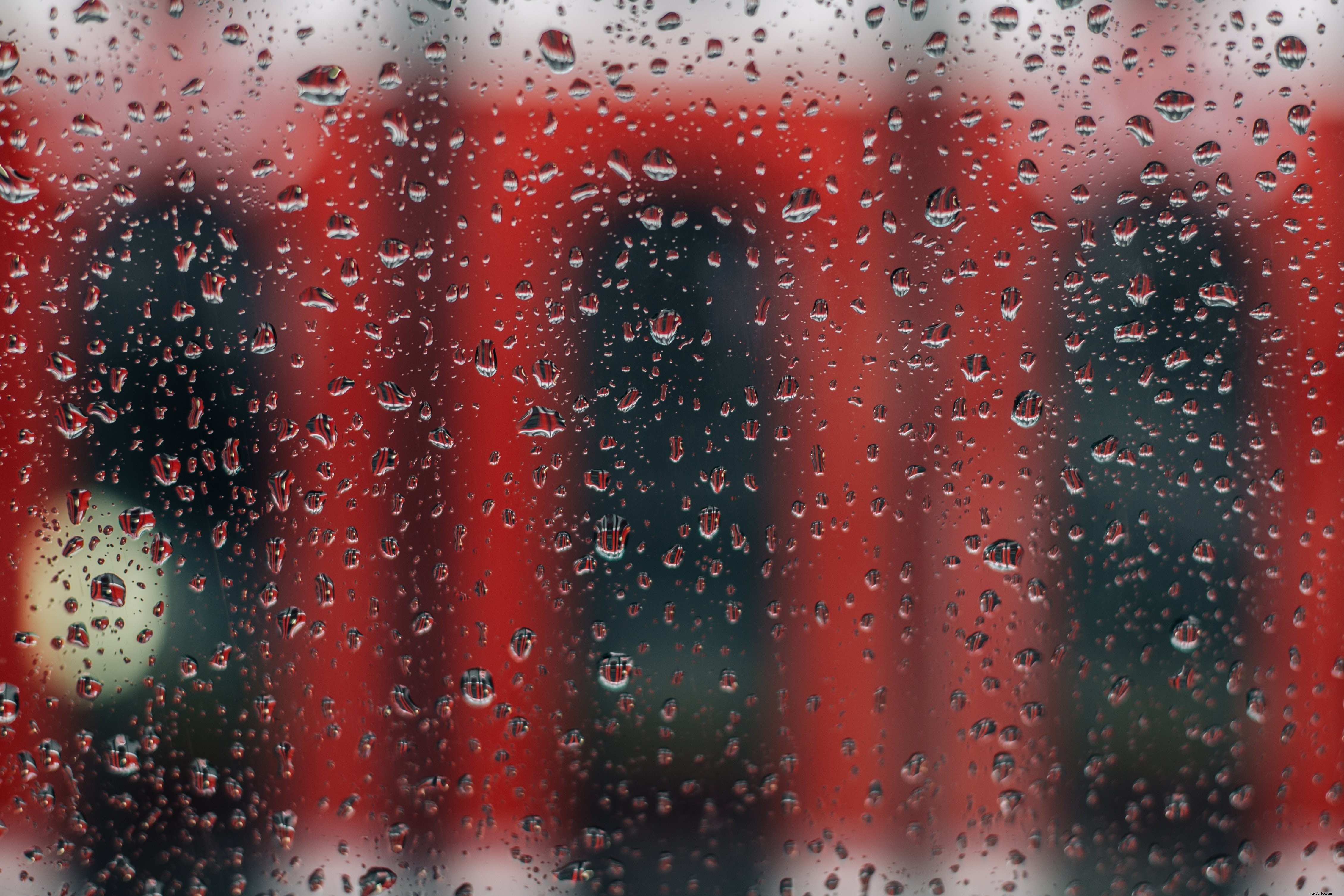 Captivating Rainy Window View: Iconic Red Streetcar Photo