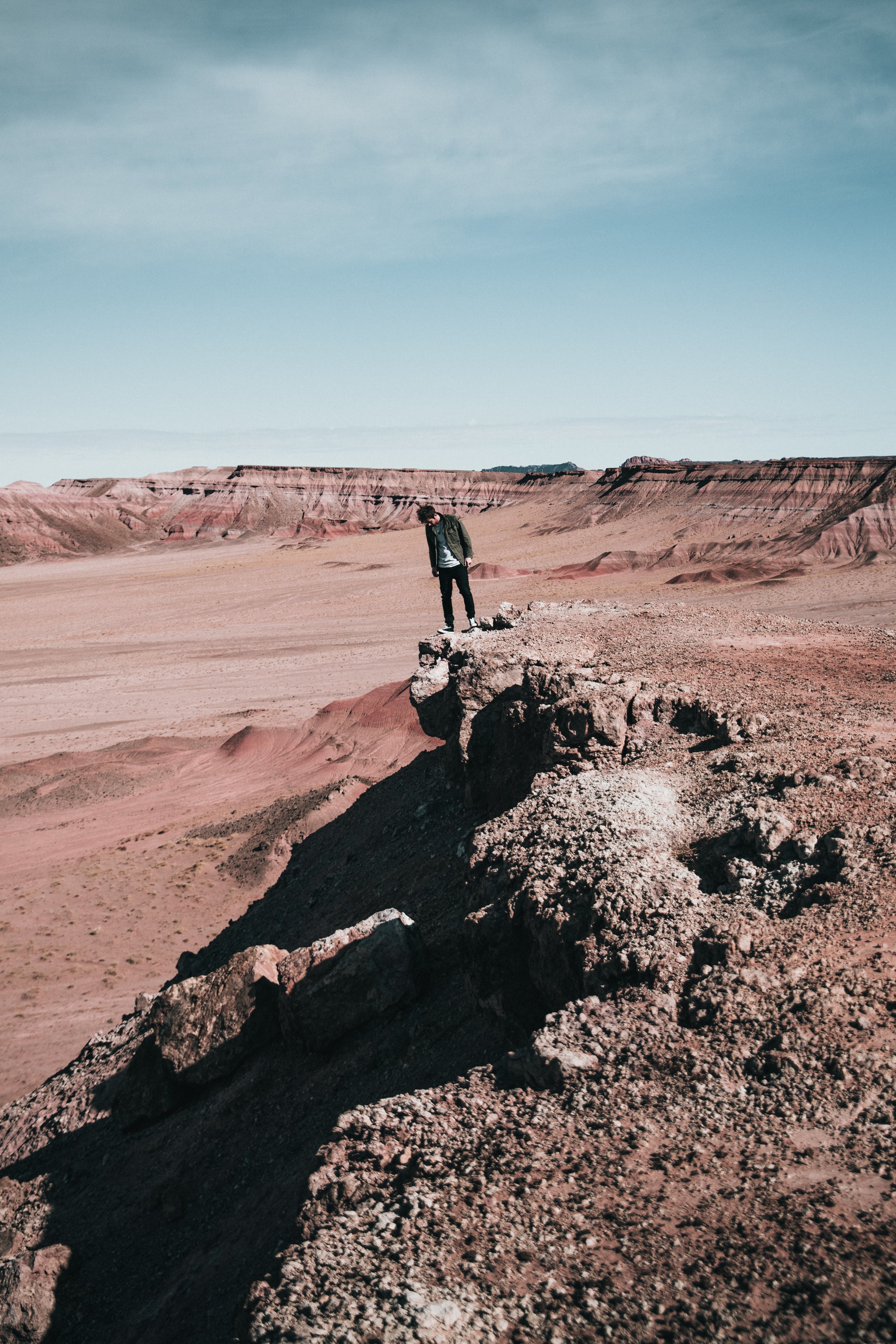 Thrilling Hiker Peering Over Rocky Cliff Edge – Stunning Adventure Photo