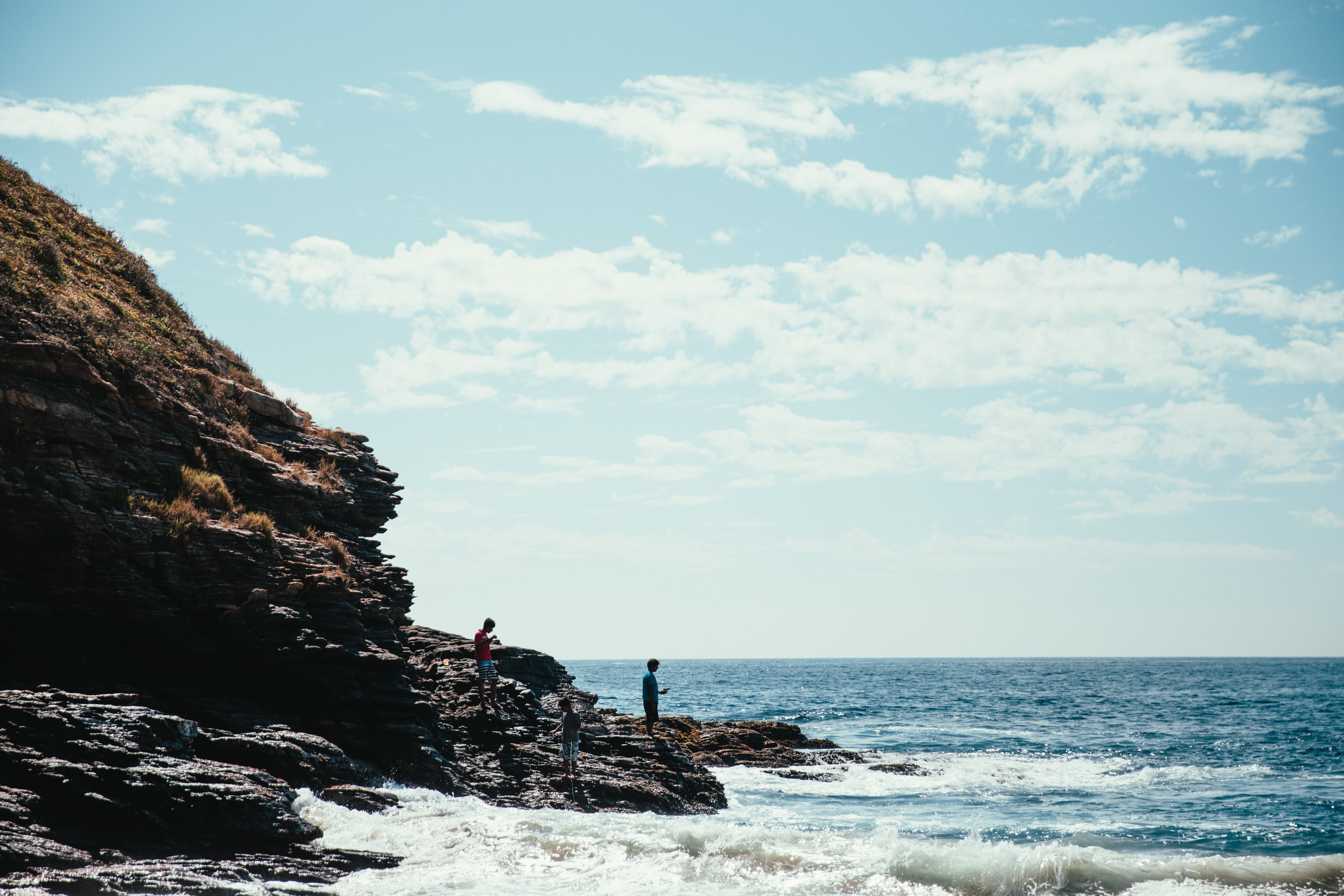 Breathtaking Hikers on Seaside Rocks: Stunning Coastal Adventure Photo
