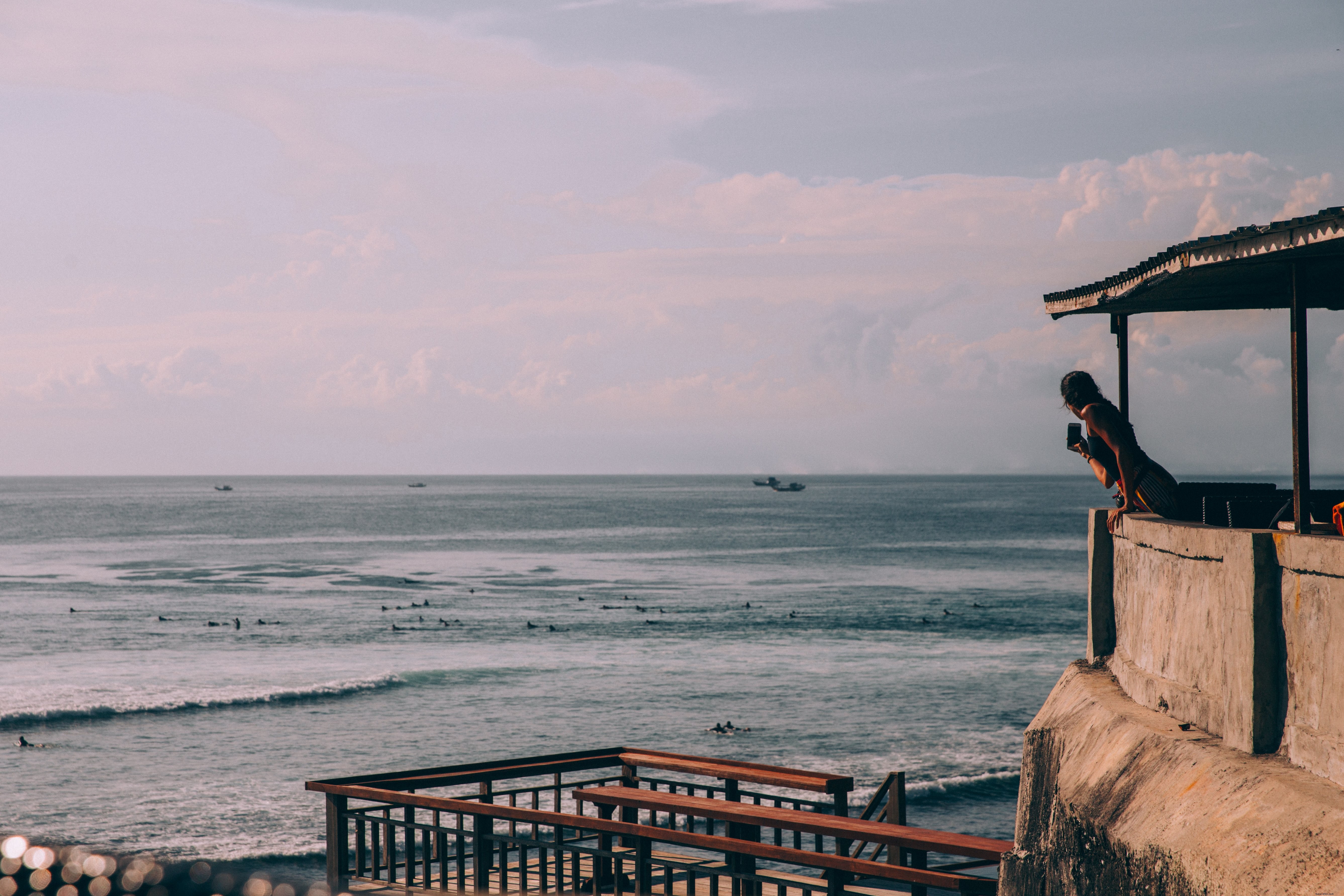 Woman Capturing Stunning Beach Scene with Her Smartphone