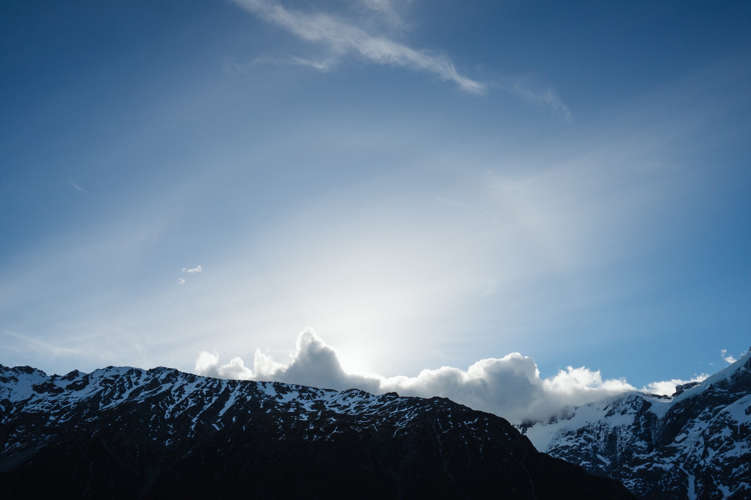 Stunning Photo: Bright Blue Sky Above Clouds Touching Majestic Mountain Peaks