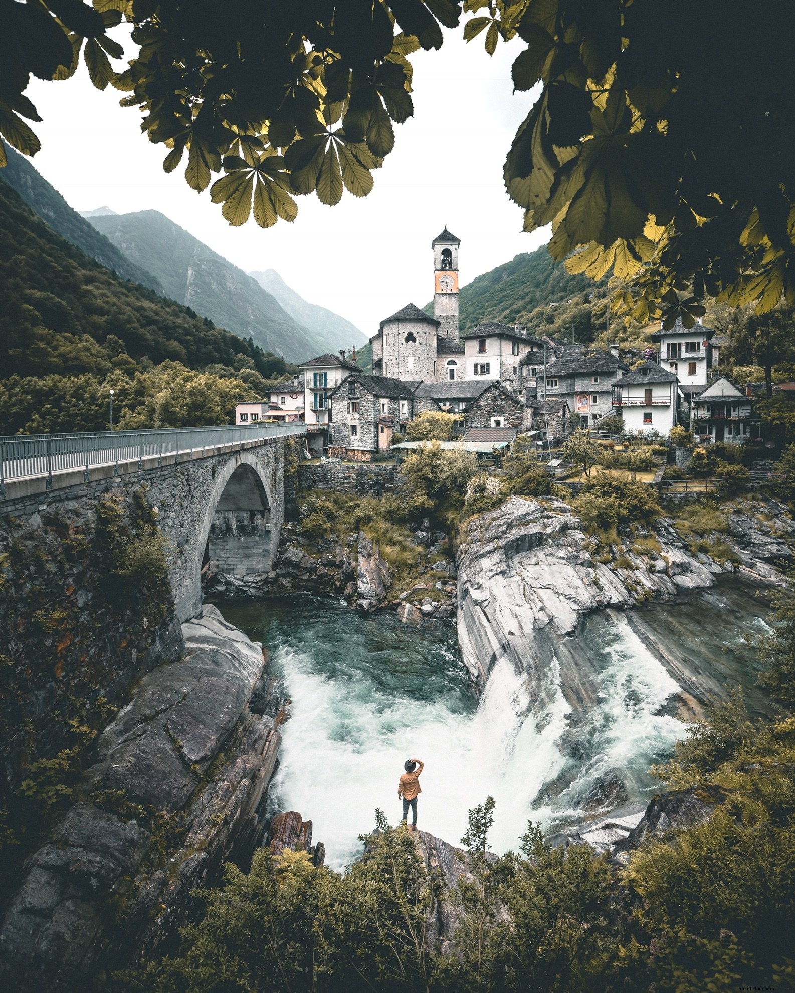 Stunning Stone Buildings Clinging to a Majestic Waterfall – Breathtaking Photo