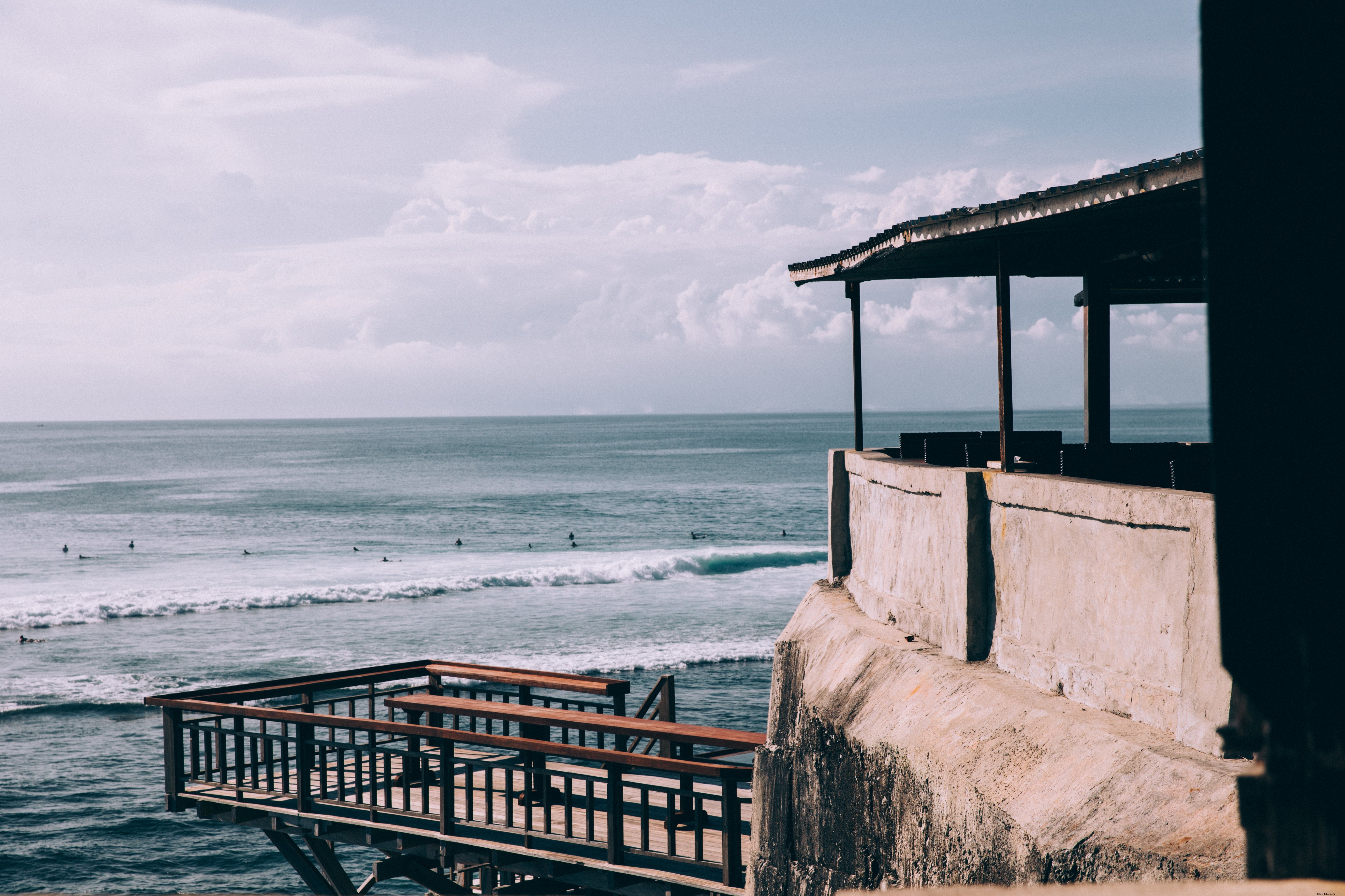 Stunning Photo: Thatched-Roof Bar Nestled in a Dramatic Rocky Alcove