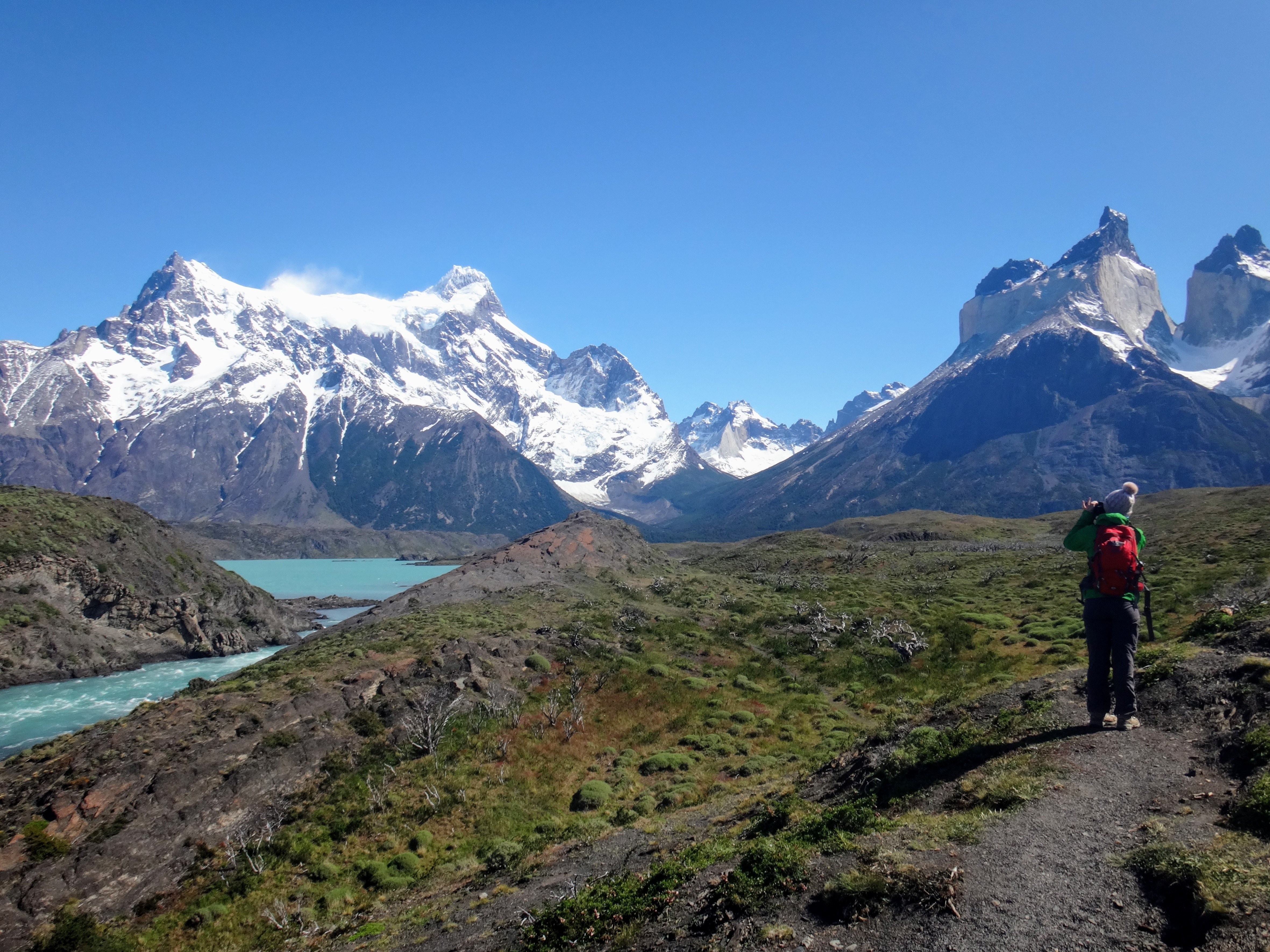 Stunning Photo of Hiker Near Majestic Snow-Capped Mountains