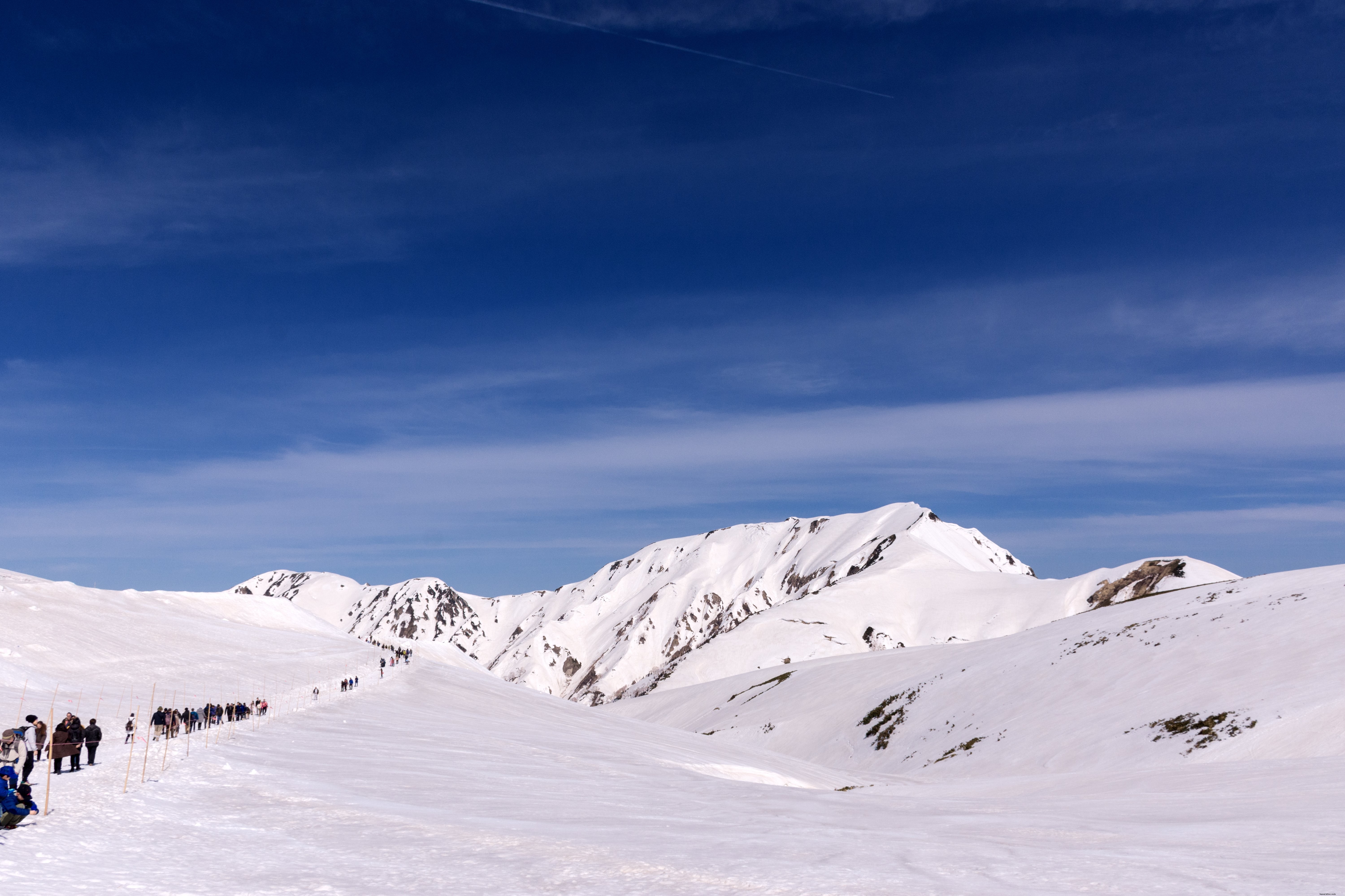 Stunning Photo: Line of Hikers Traversing Snow-Capped Mountains