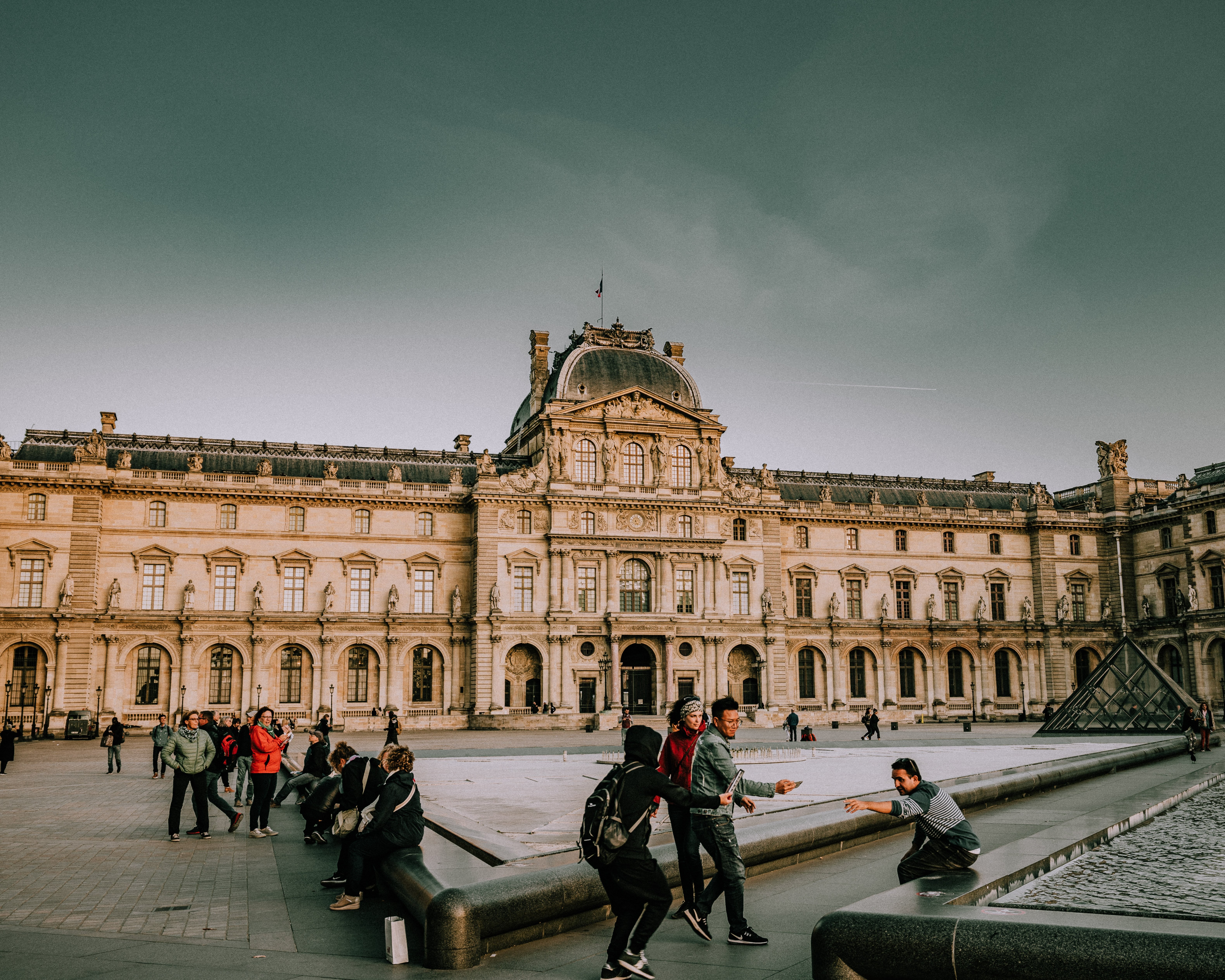 Tourists Capturing Iconic Moments Outside the Louvre Pyramid