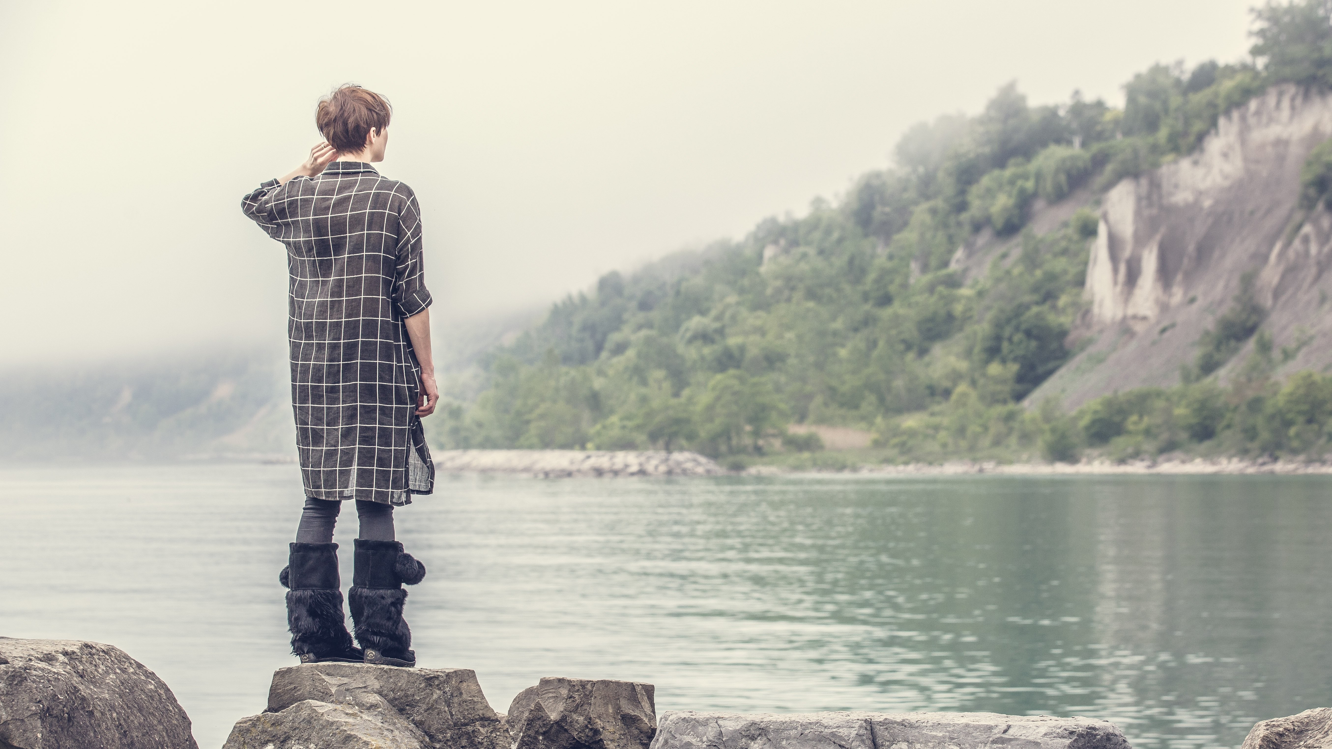 Stunning Photo: Woman Gazing at Dramatic Rocky Shoreline