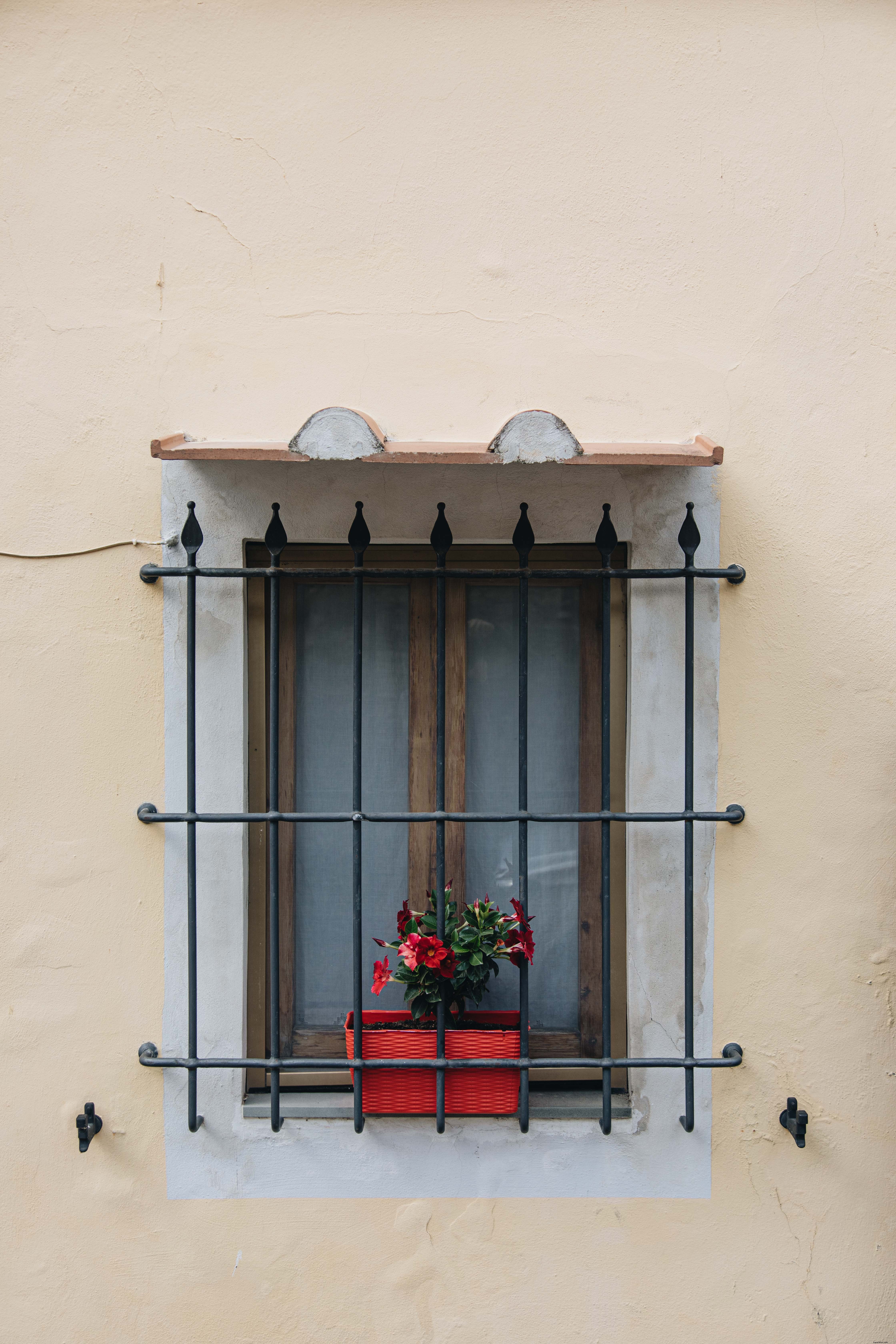 Stunning Window with Iron Grilles on Vibrant Yellow Building – Professional Photo