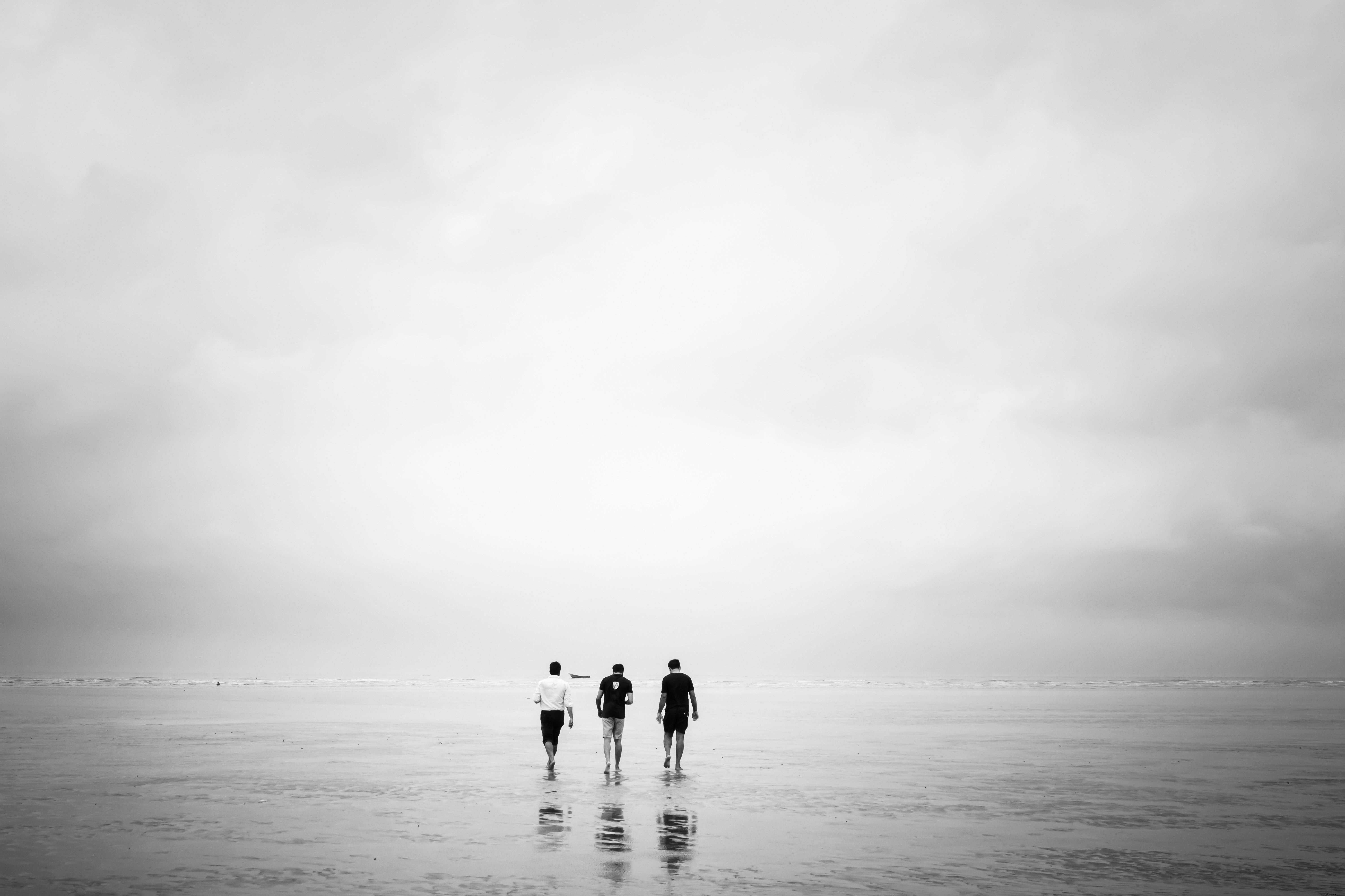 Captivating Photo: Three Men Strolling Across a Low-Tide Beach