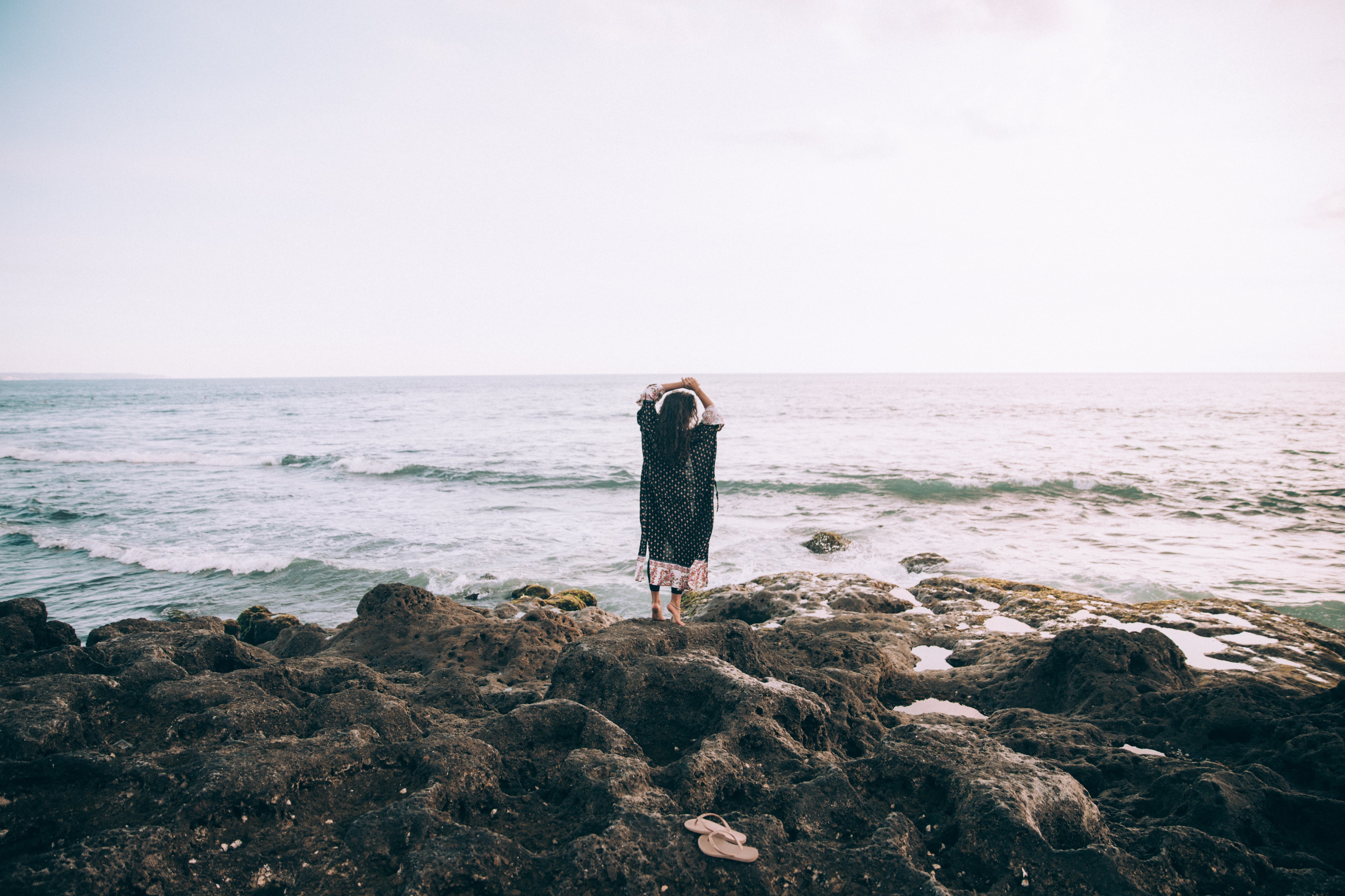 Serene Woman in Reverie by the Beach – Arms Raised in Tranquil Bliss Photo