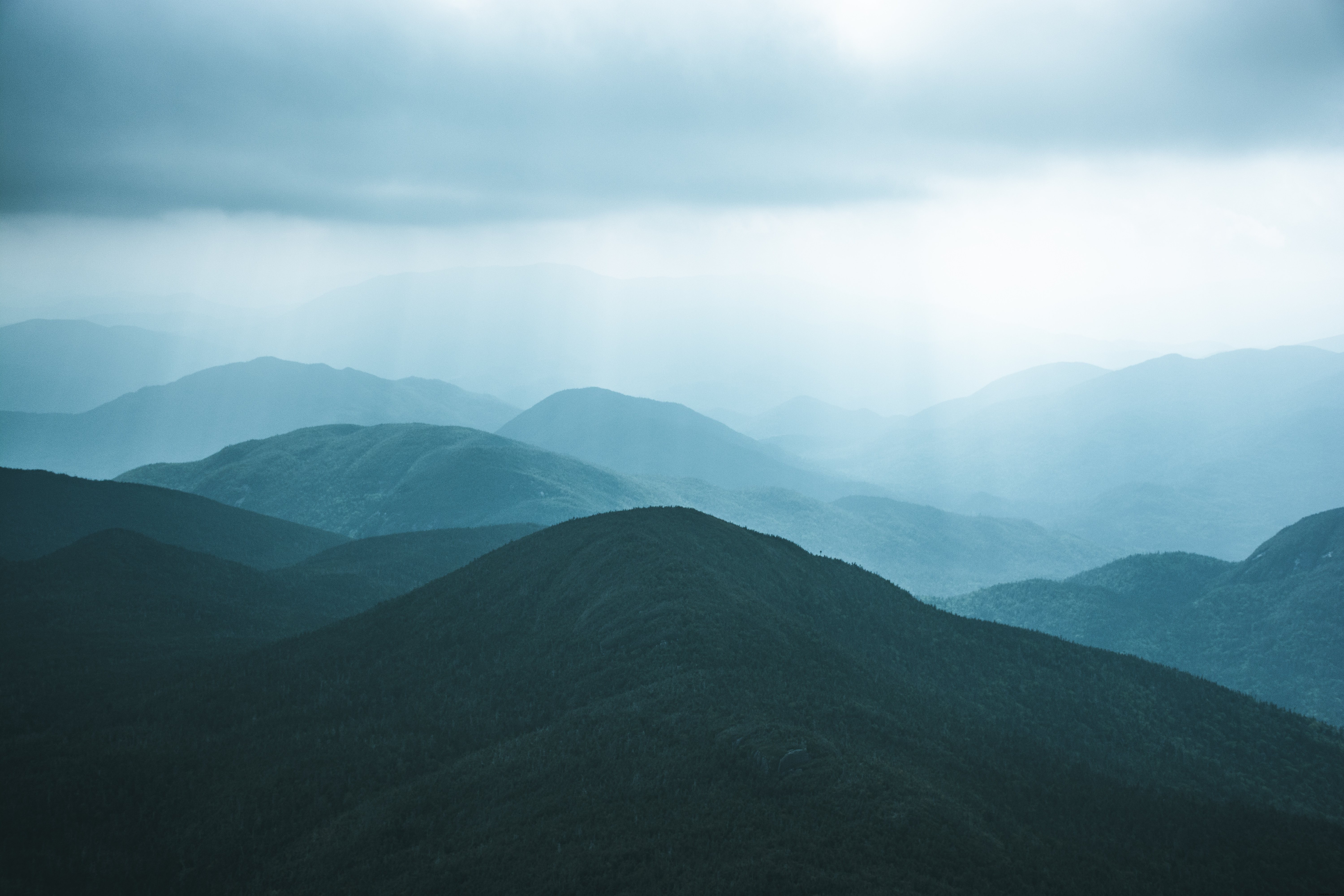 Captivating Landscape: Tree-Covered Hills Under a Moody Grey Sky