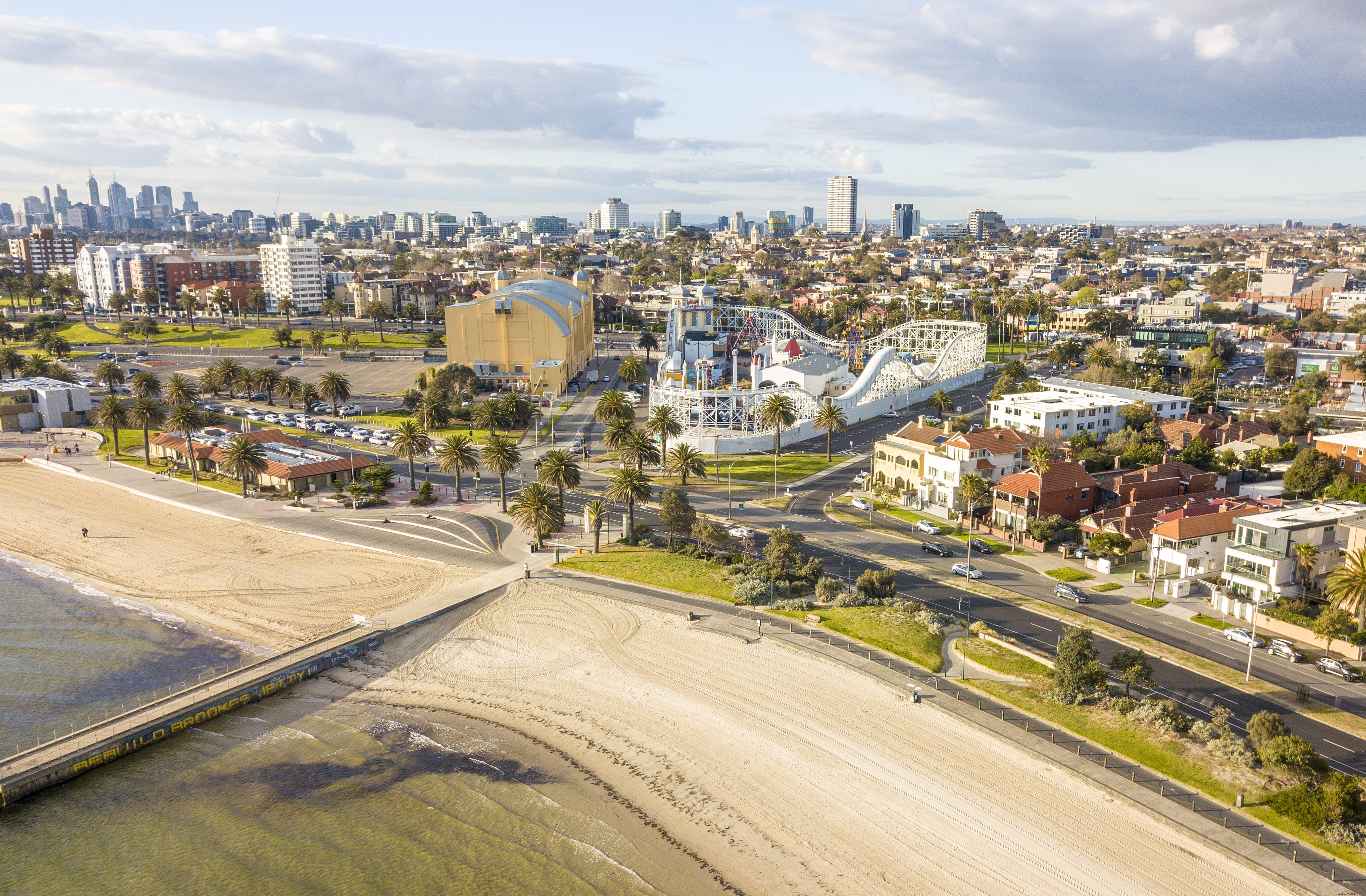 Stunning Aerial View: Coastal City Skyline with Thrilling Roller Coaster