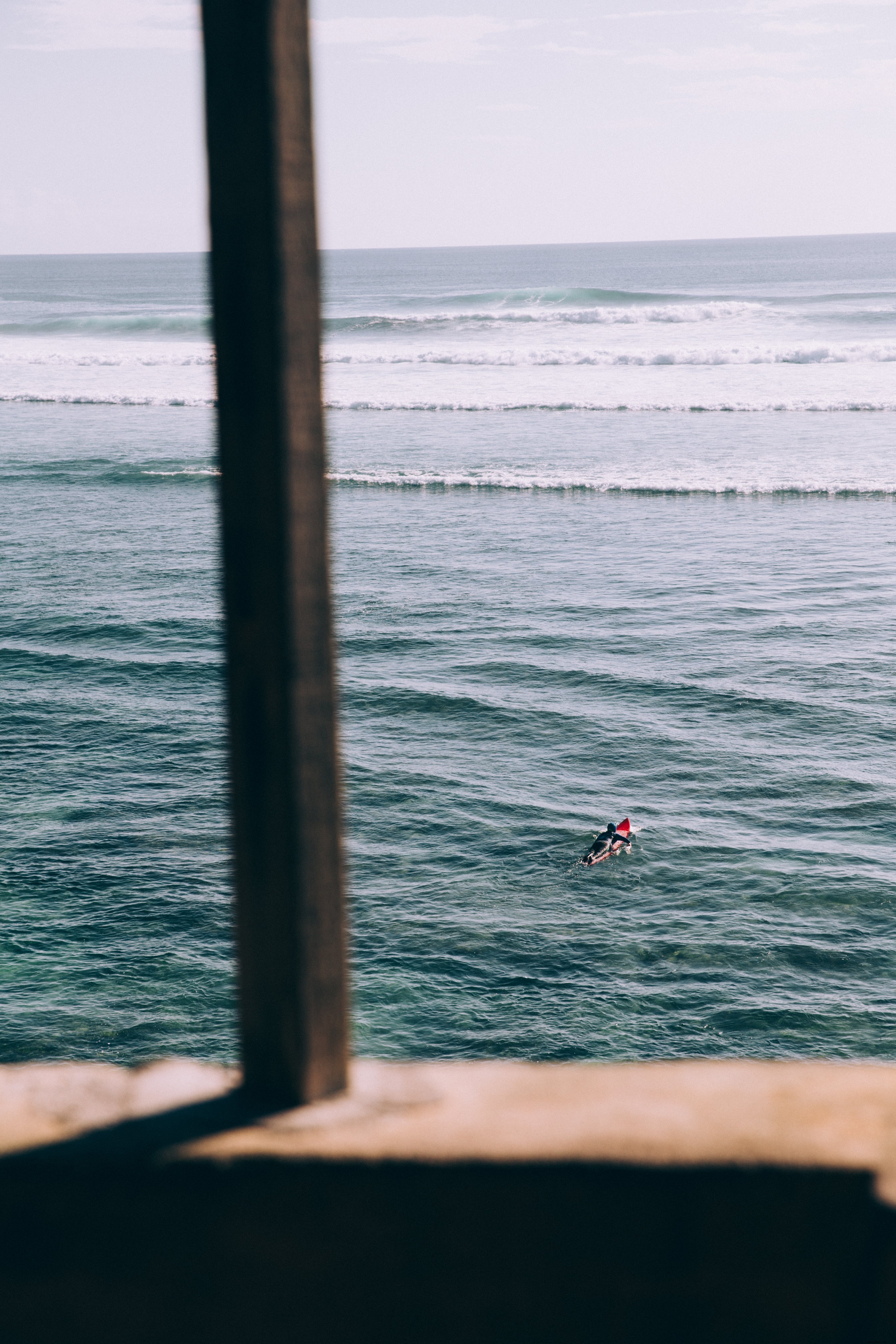 Stunning Photo: Solitary Surfer Paddles Out to Towering Waves