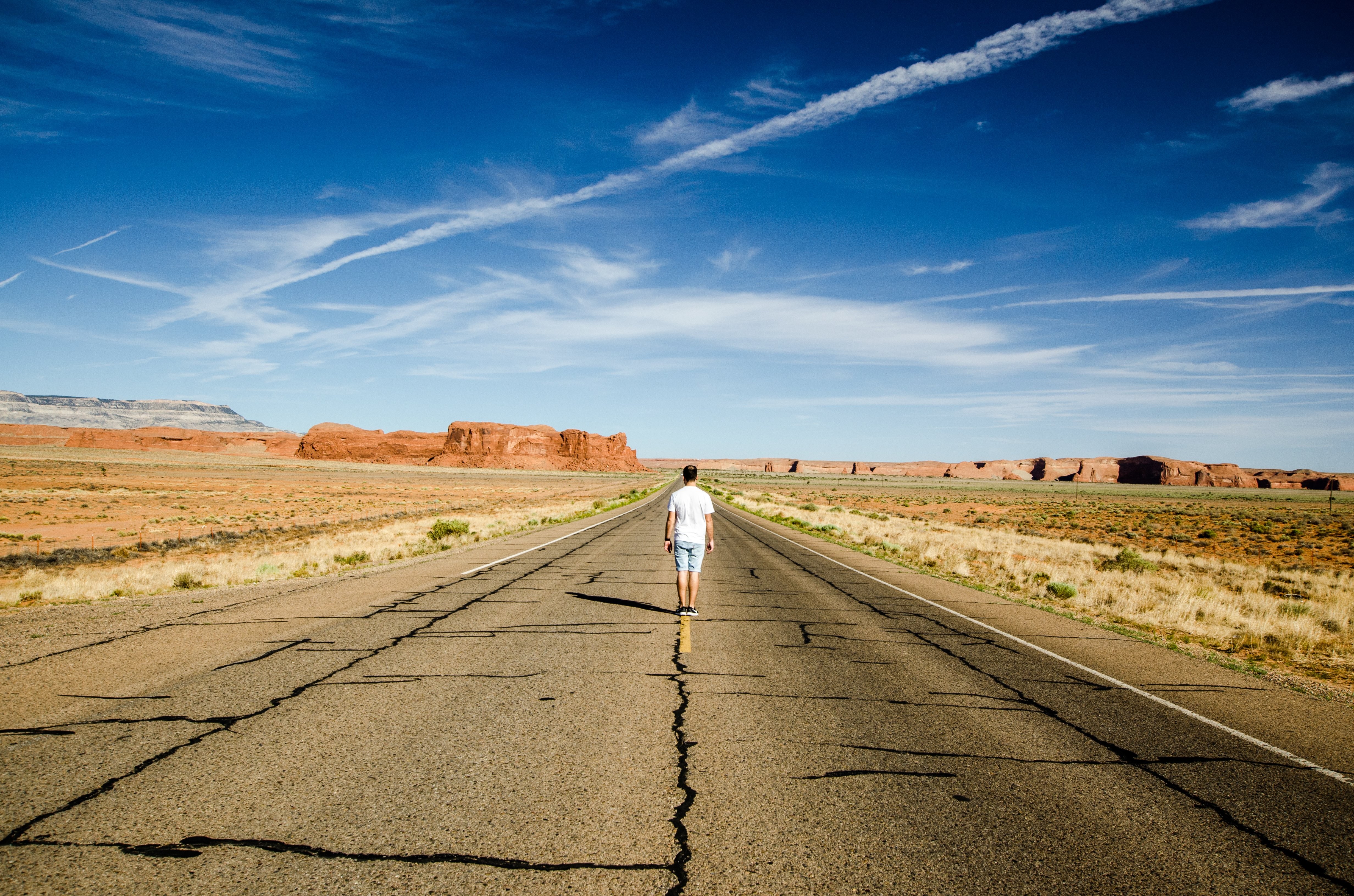 Lone Man Standing on Desert Highway Road Markings – Captivating Photo