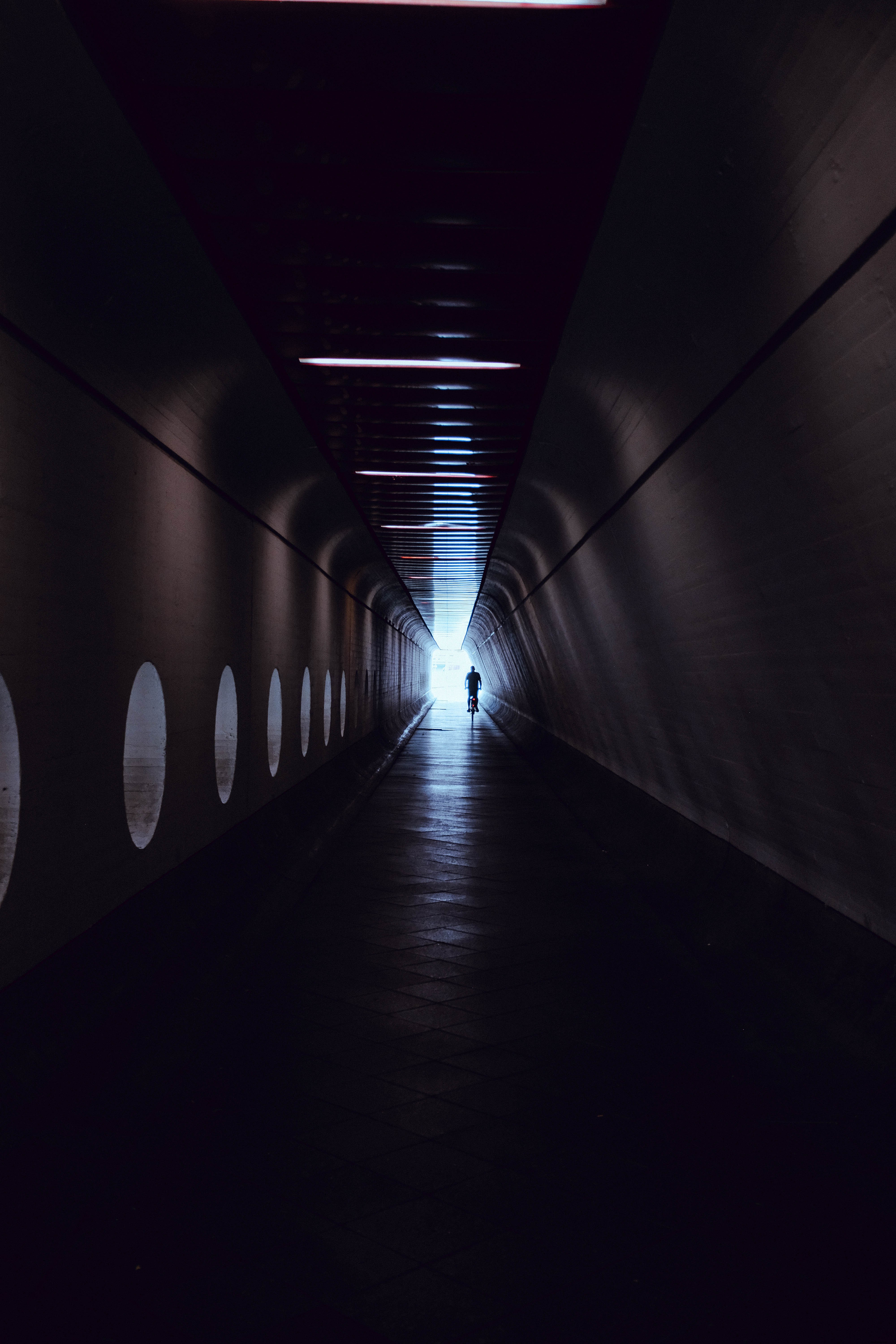 Captivating Photo: Man Riding Bicycle Through Urban Tunnel