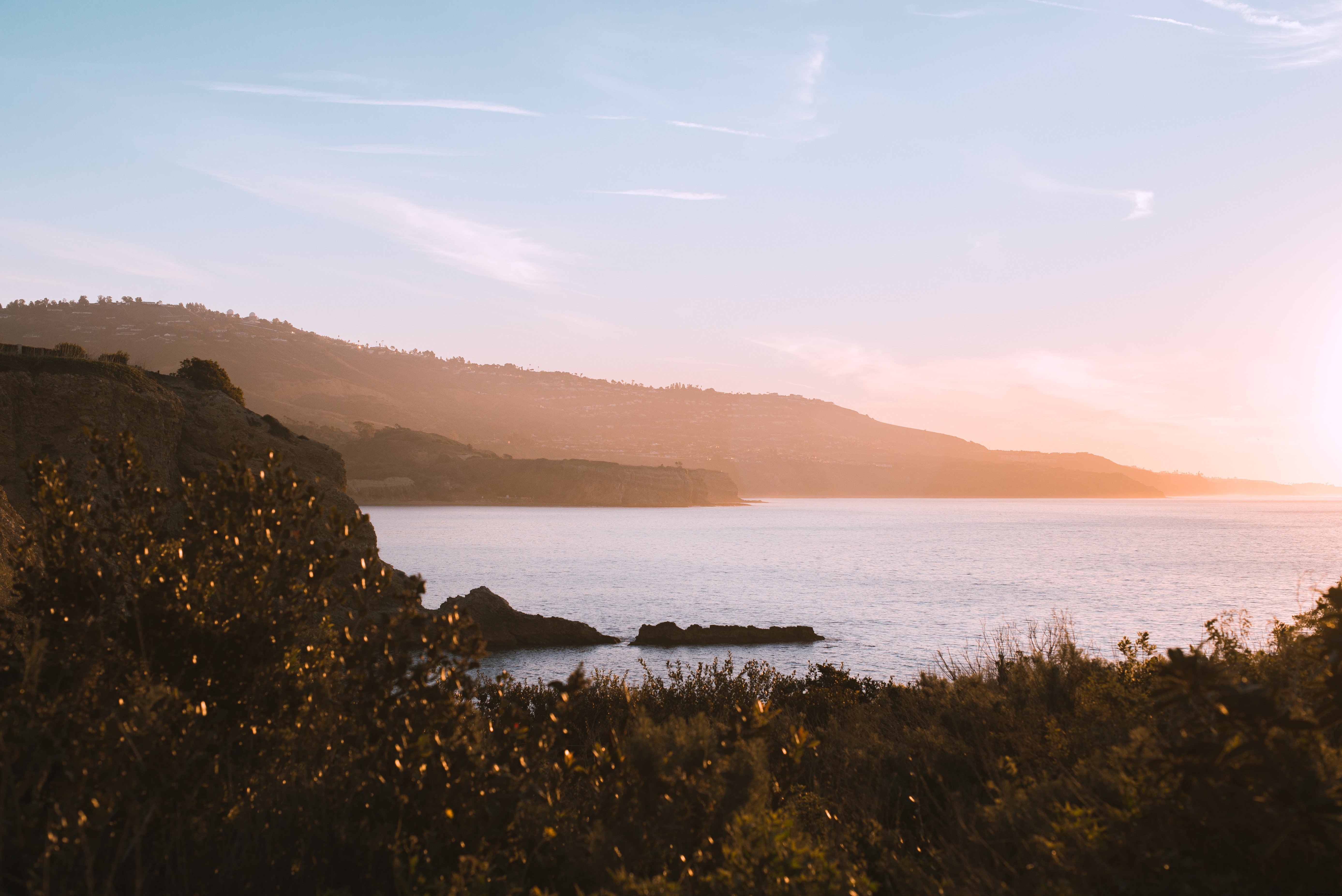 Stunning Photo: Sunlight Piercing Morning Mist Over Serene Waters