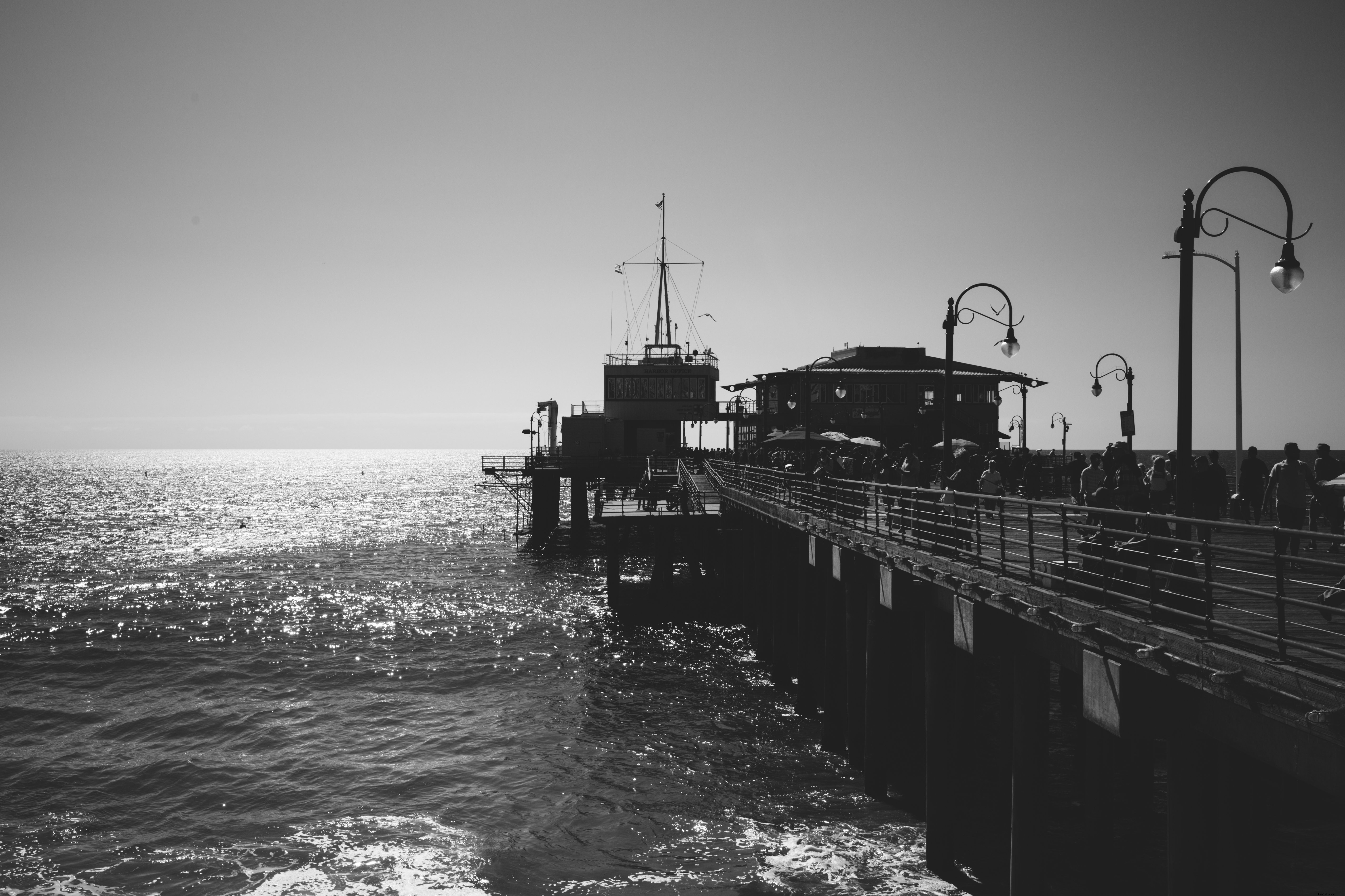 Stunning Black & White Photo: Bustling Pier Overlooking Serene Waters