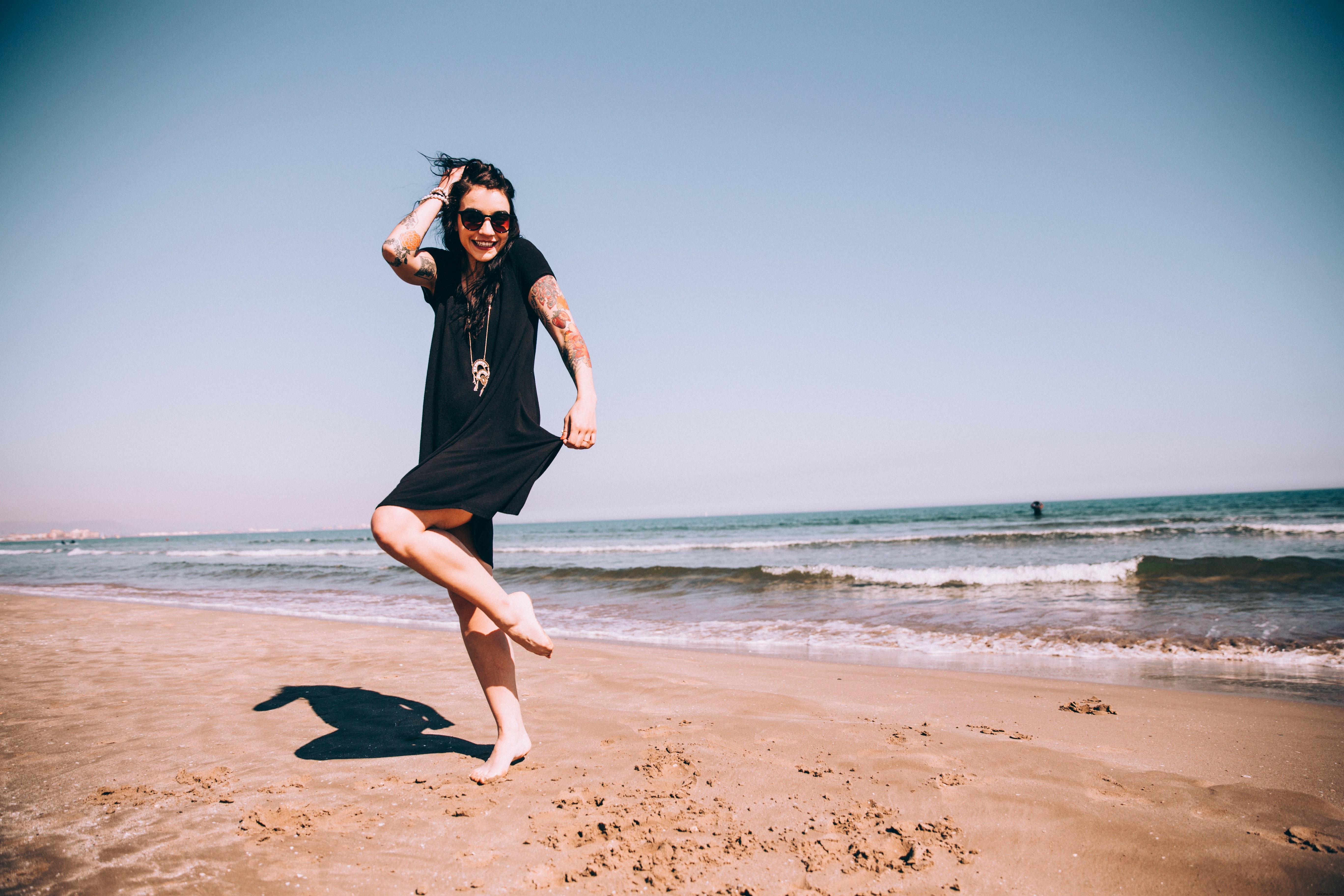 Captivating Photo: Tattooed Woman Basking in the Sun on a Pristine Beach