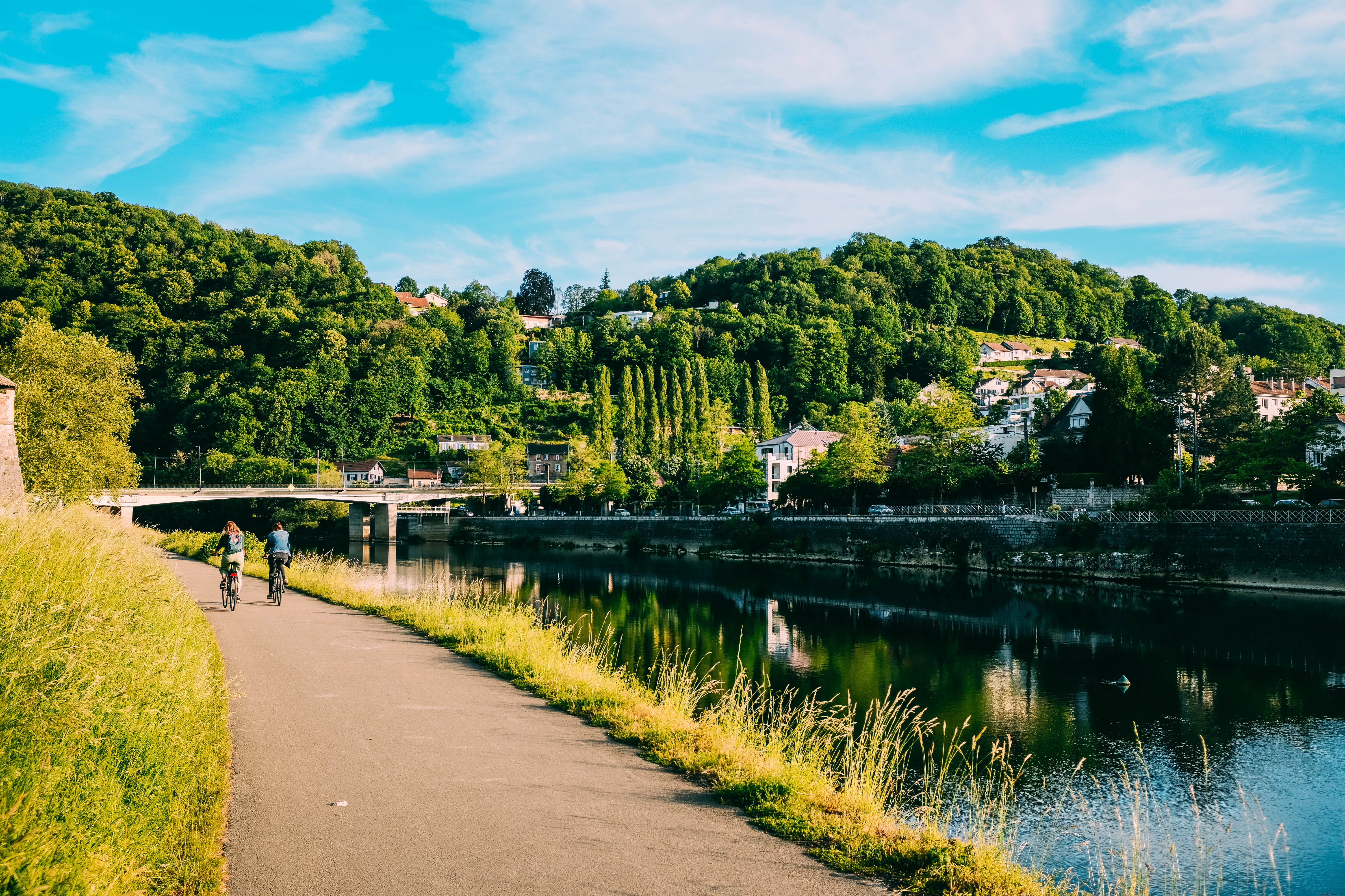 Stunning Photo: Cyclists Gliding Gracefully Along the Riverside