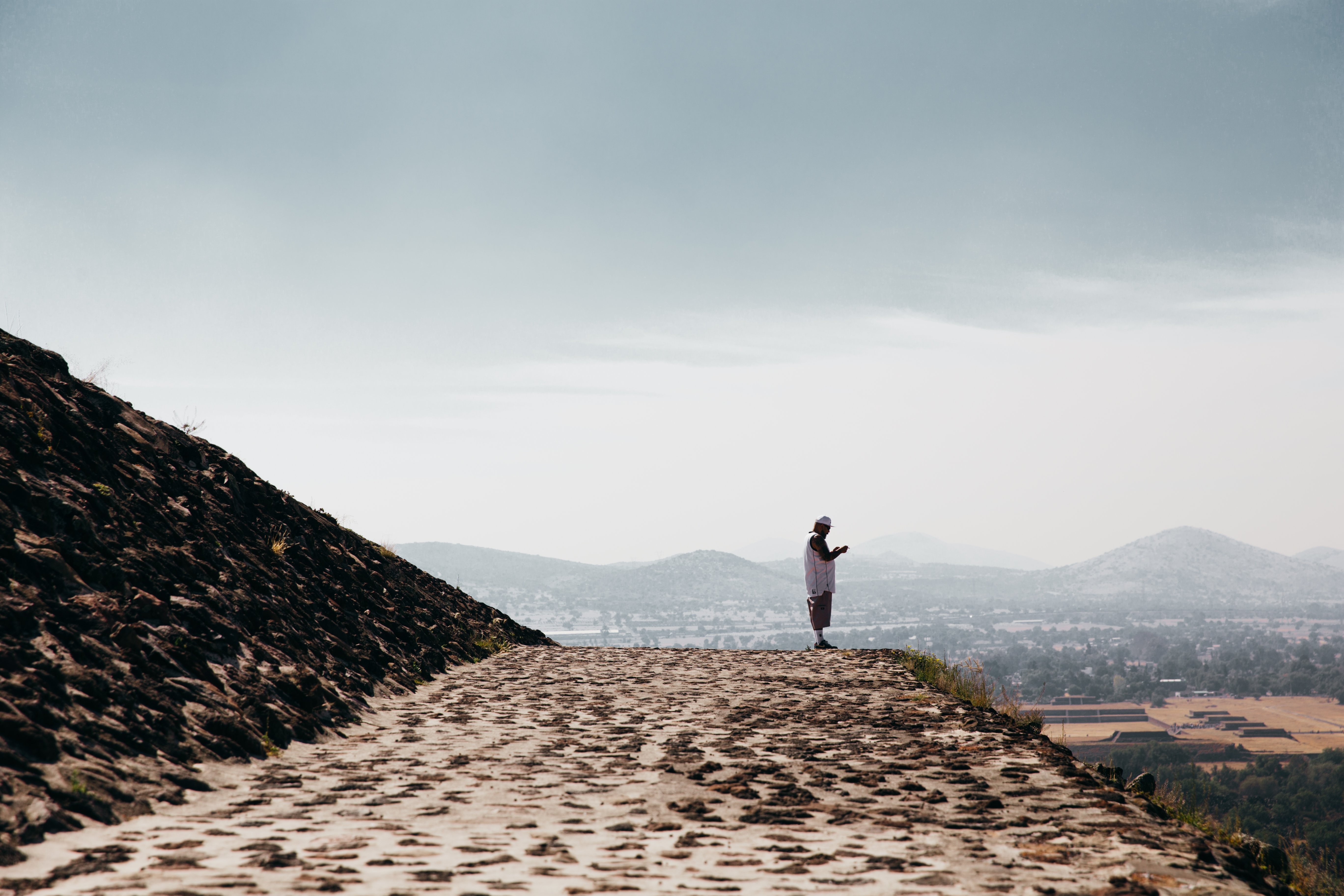 Devout Man Praying on Ancient Stone Temple Ledge – Captivating Photo