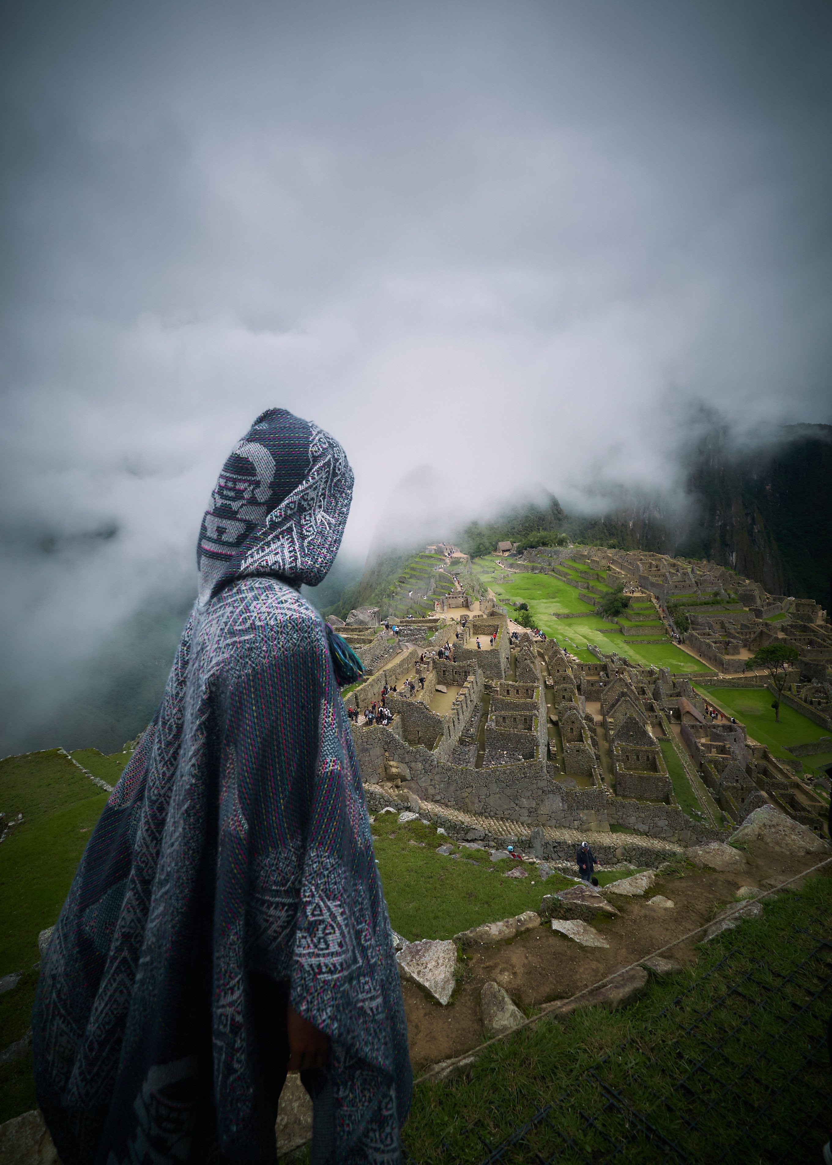 Mysterious Hooded Figure Overlooking Ancient Ruins – Captivating Photo