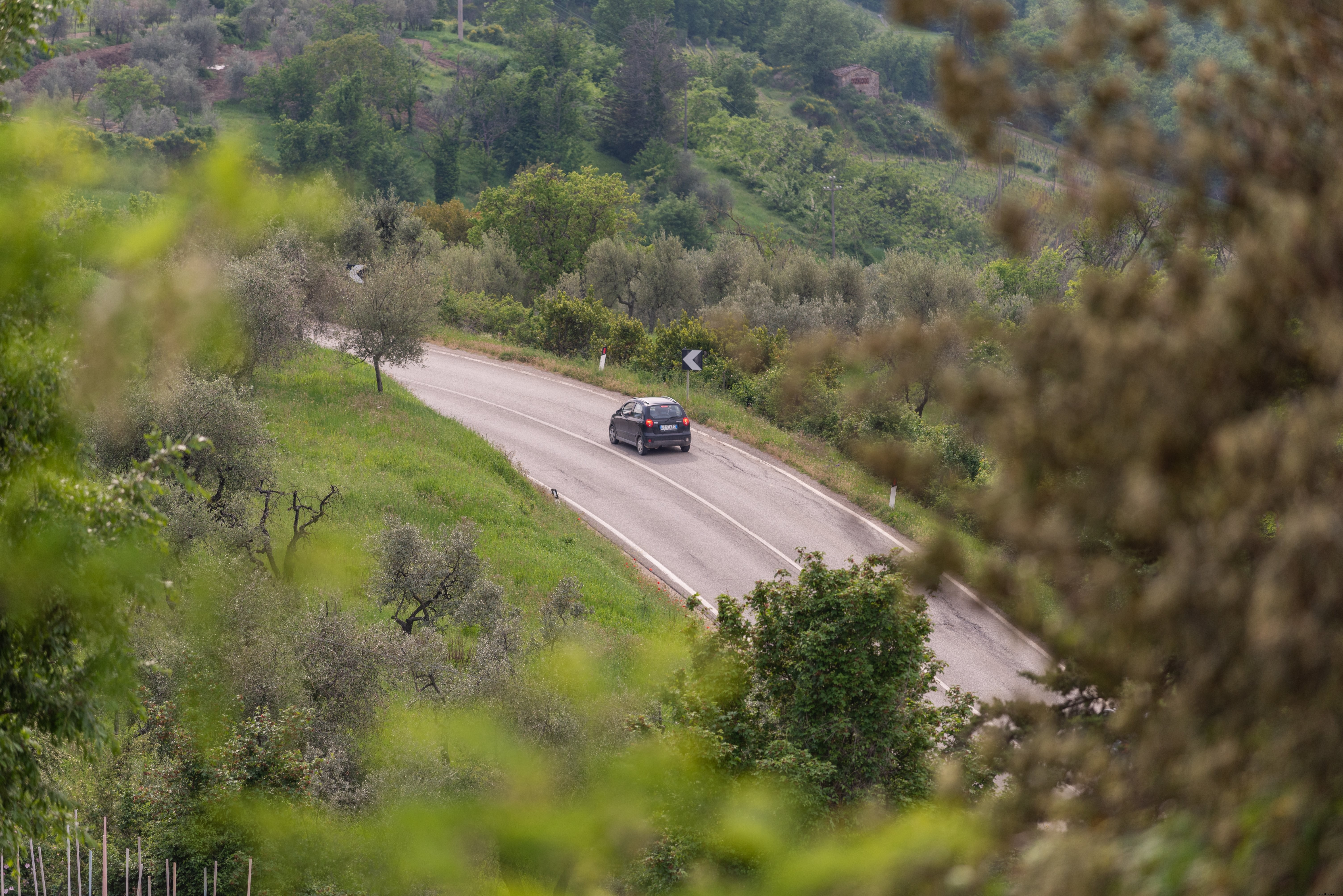 Stunning Photo: Car Navigating a Sharp Curve on Scenic Hill Highway