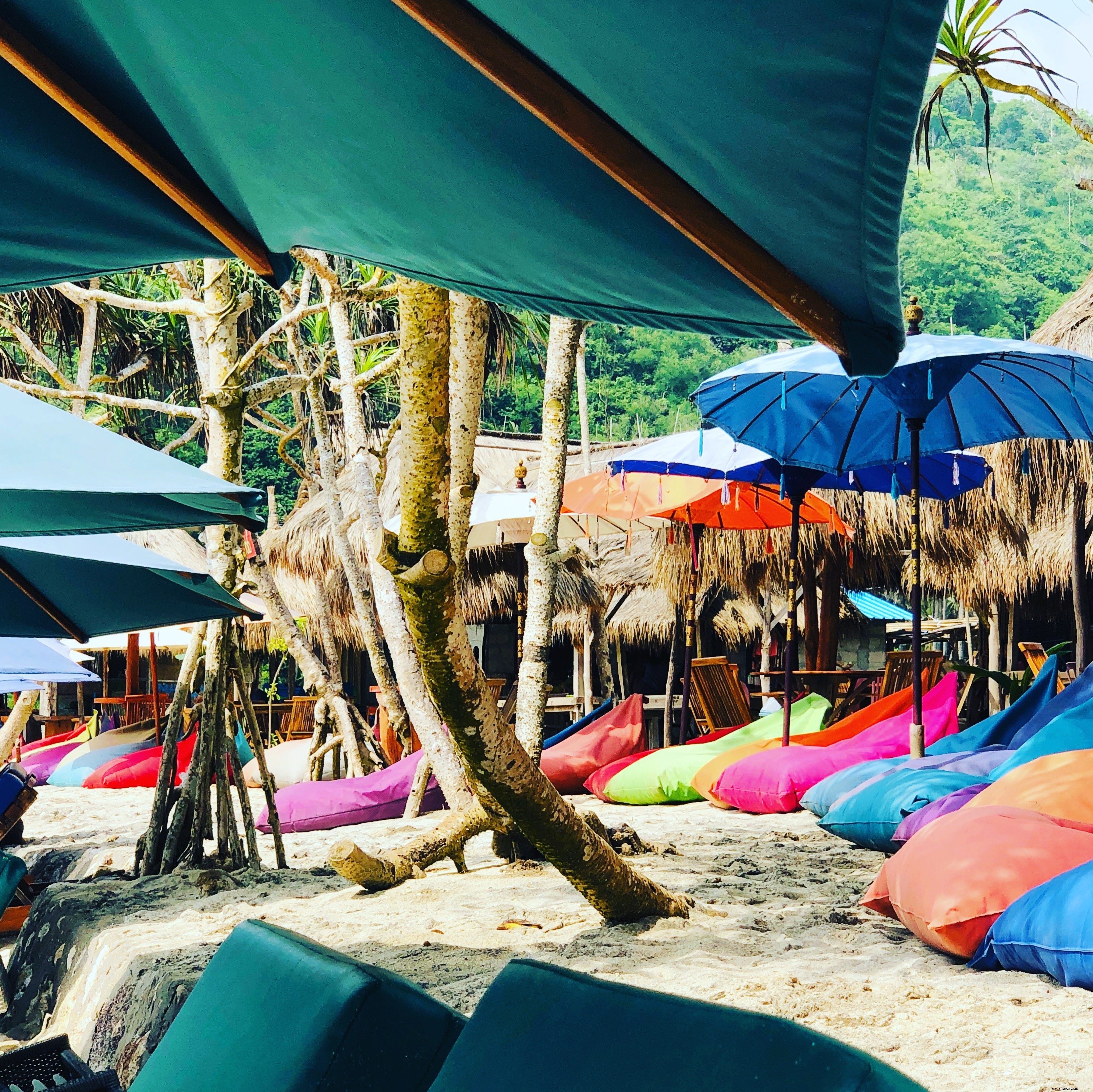 Vibrant Colorful Bean Bags on a Sunny Beach Under Blue Umbrellas and Palm Trees – Stunning Photo