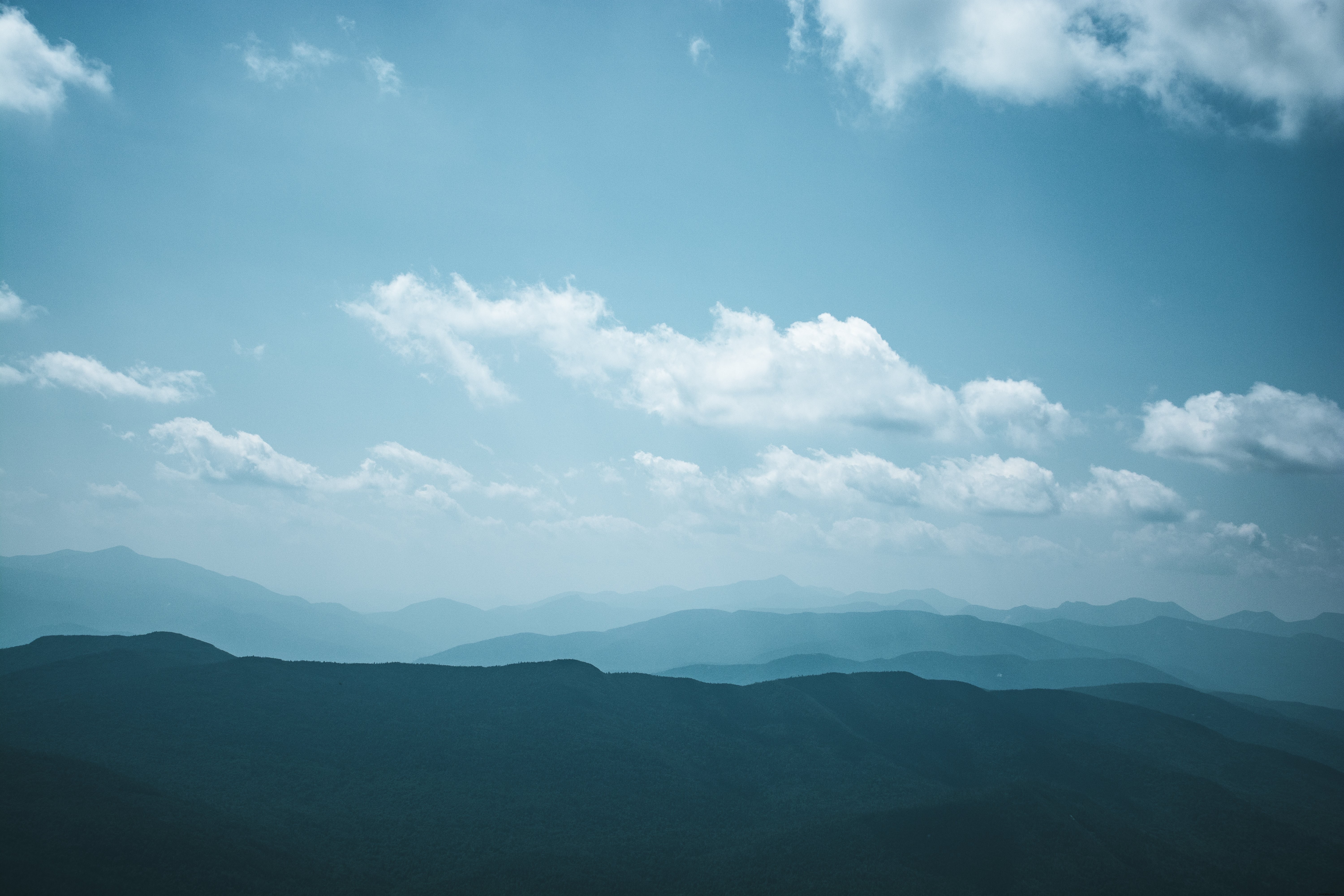 Stunning Landscape: White Clouds in Vibrant Blue Sky Over Rolling Hills