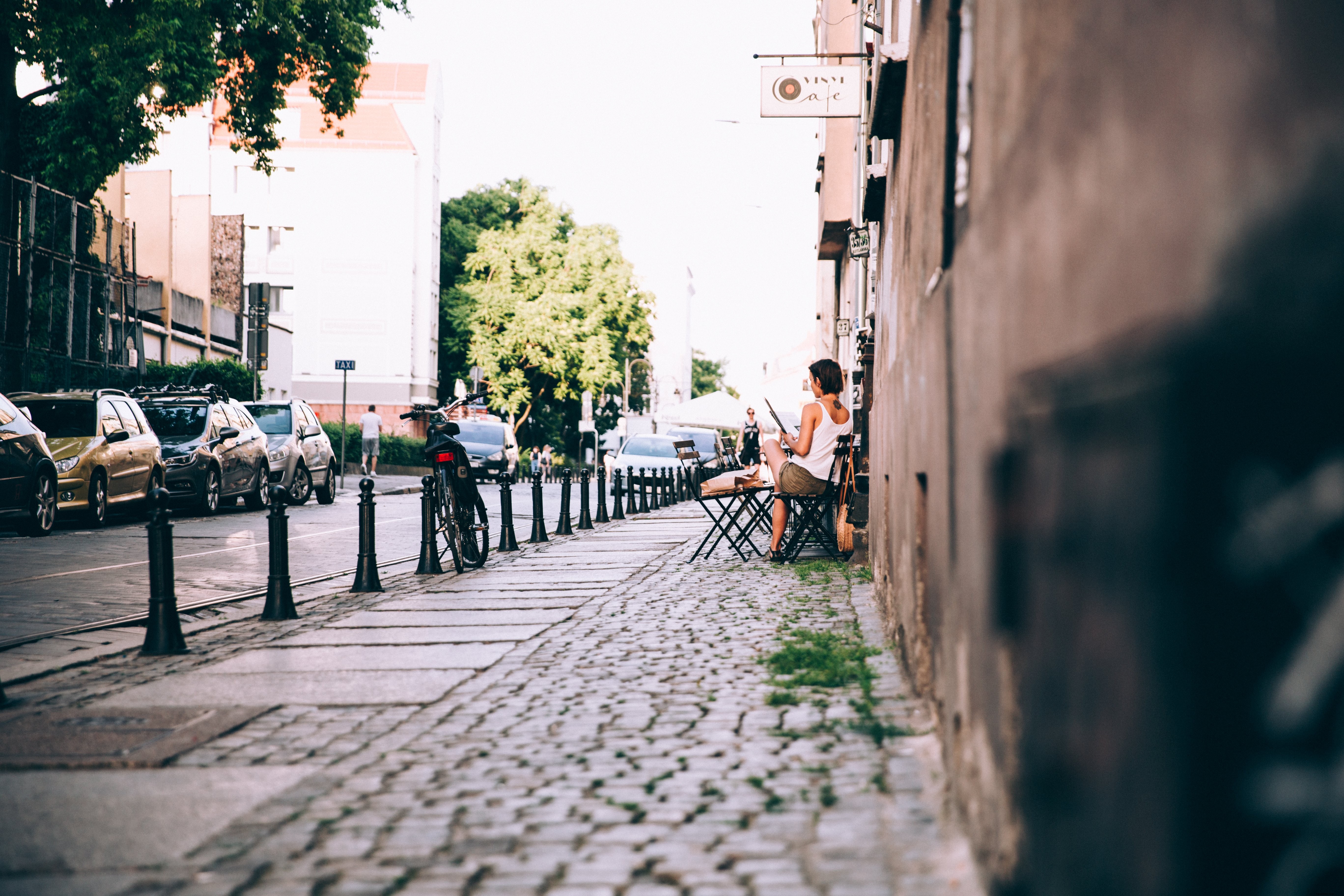 Elegant Woman Reading Newspaper at Outdoor Café – Stunning Lifestyle Photo