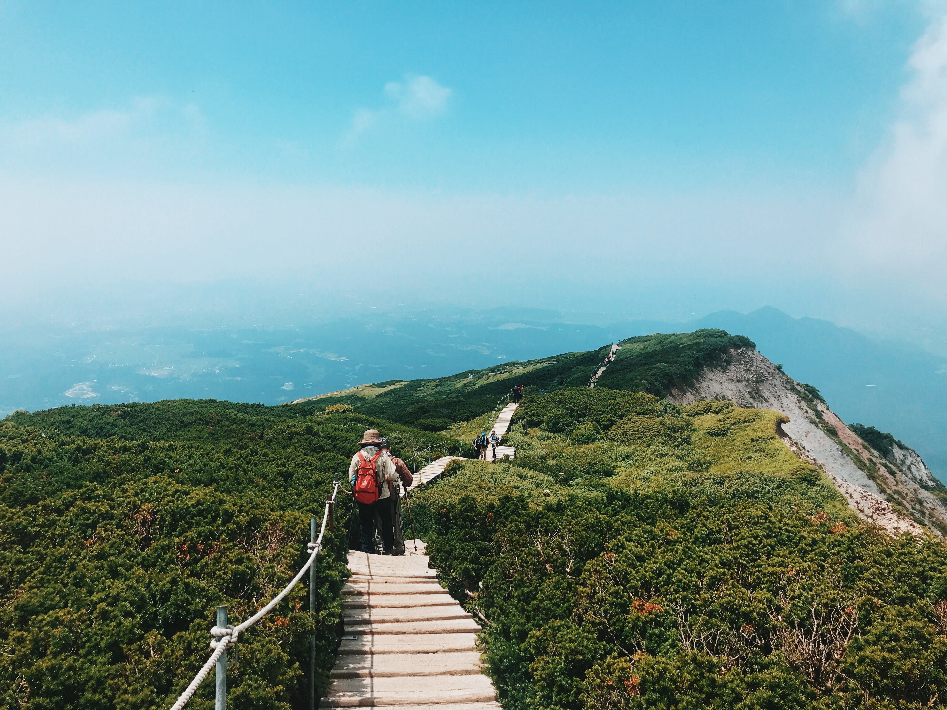 Stunning Photo of Hikers Trekking Lush Green Mountain Peaks