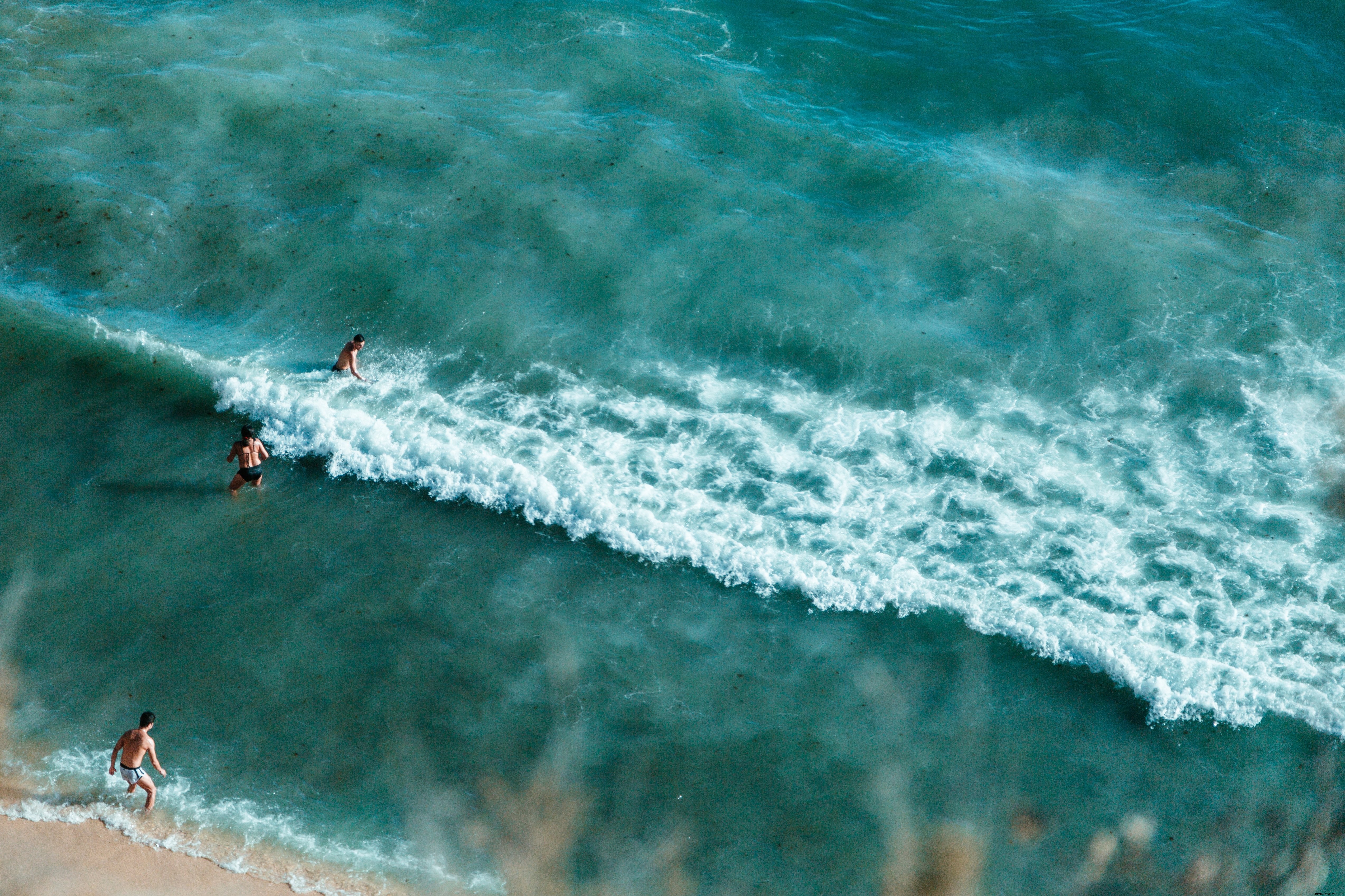Stunning Photo: Bathers Wading into Crystal Turquoise Waters at Pristine Sandy Beach