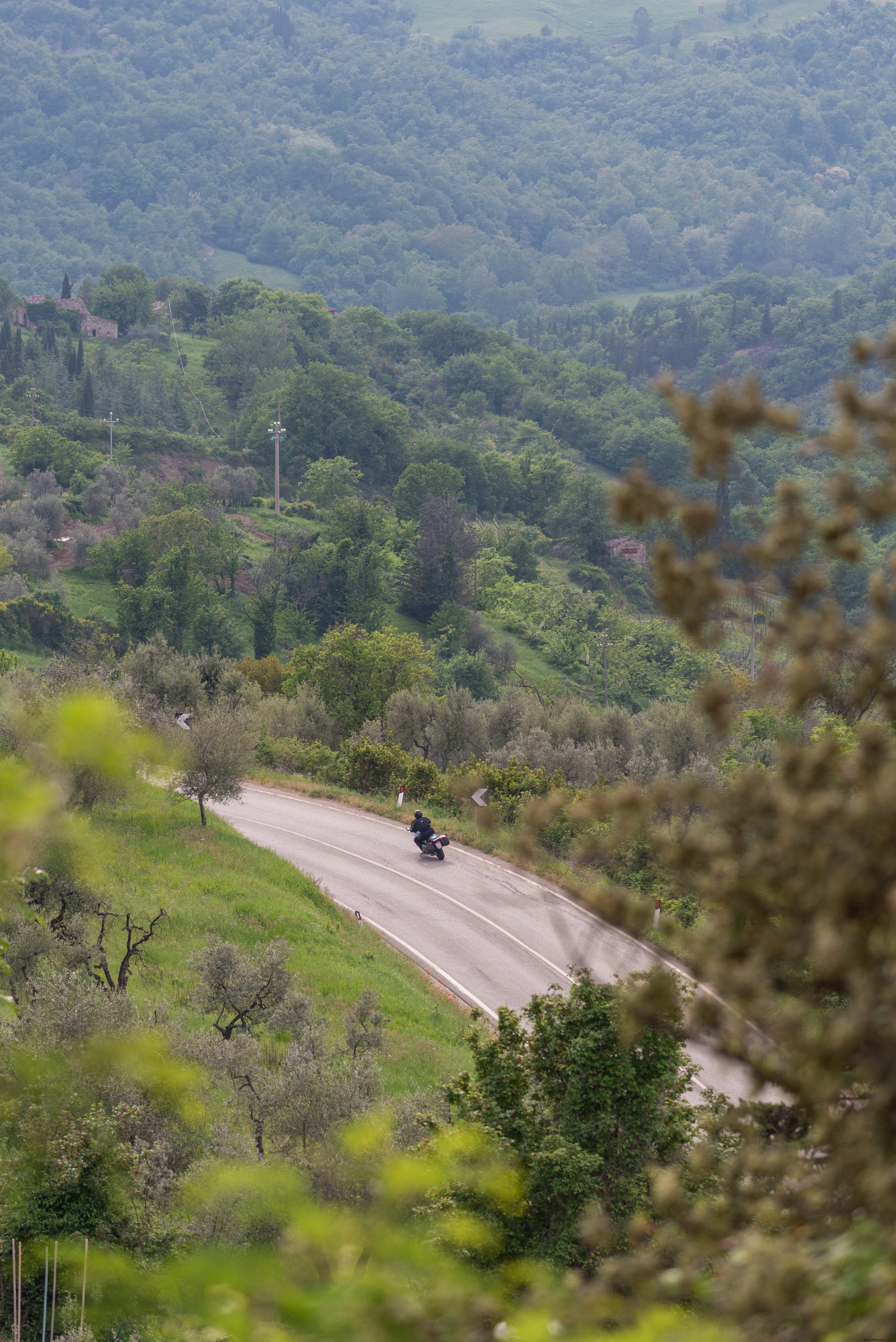 Stunning Photo: Motorcycle Leaning into a Sharp Highway Curve Around a Hill