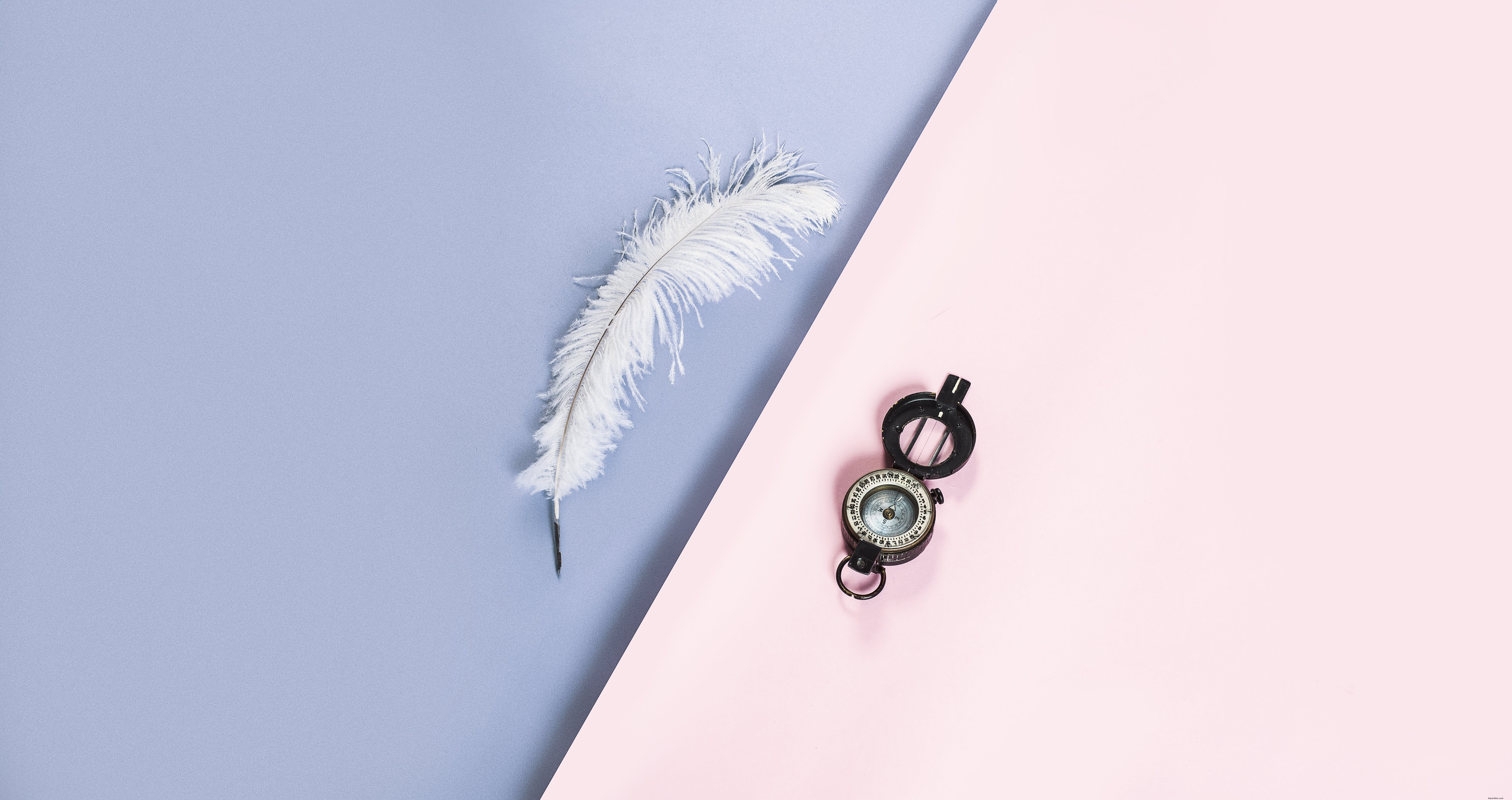Elegant White Feather Quill and Compass on Vibrant Pink-Purple Background