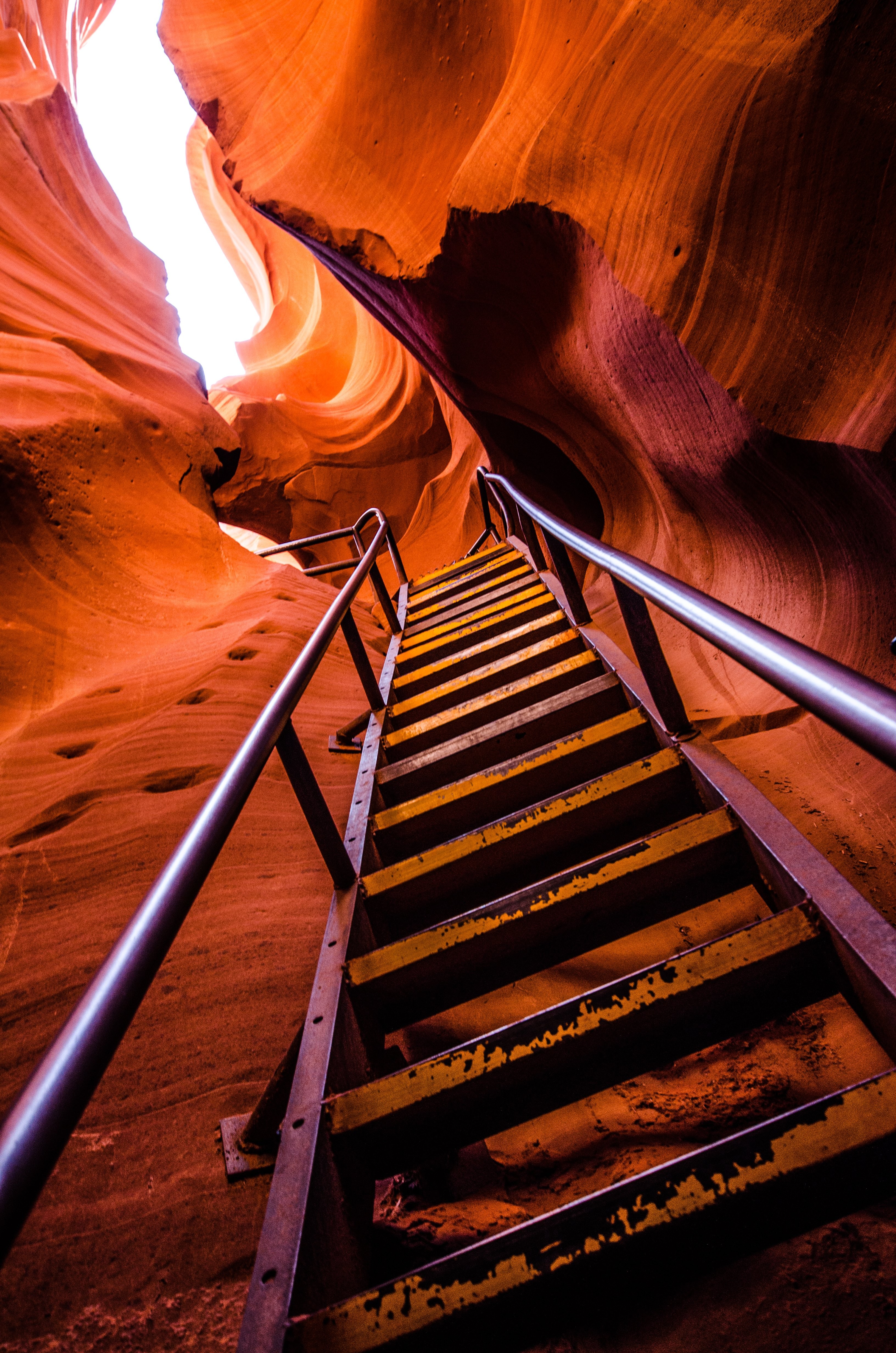 Stunning Photo: Ladder Scales Steep Red Sandstone Cave Walls