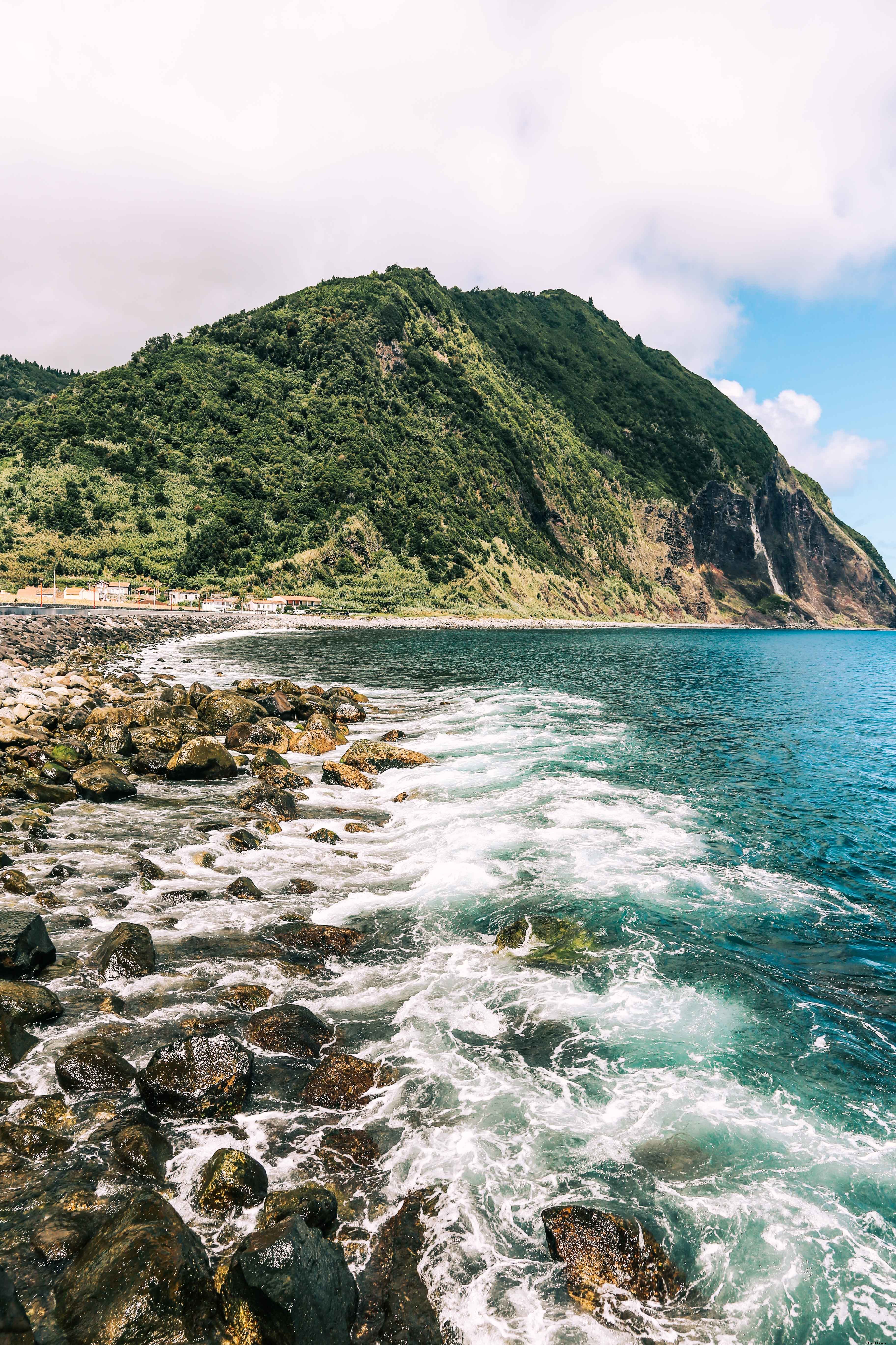 Stunning Photo: Waves Gently Lapping at Majestic Mountain Base