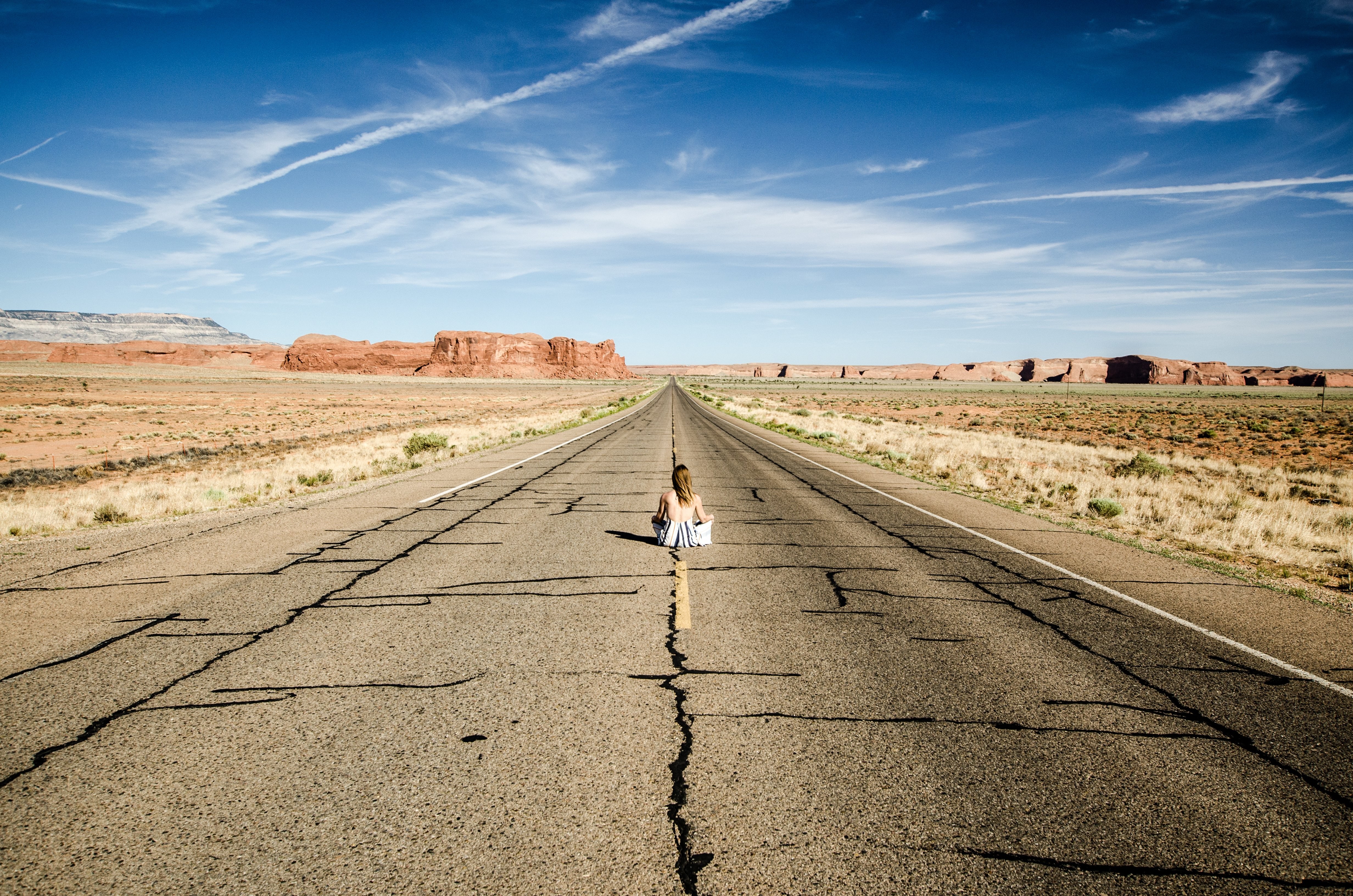 Stunning Photo: Woman Sits Boldly in the Middle of a Desert Highway