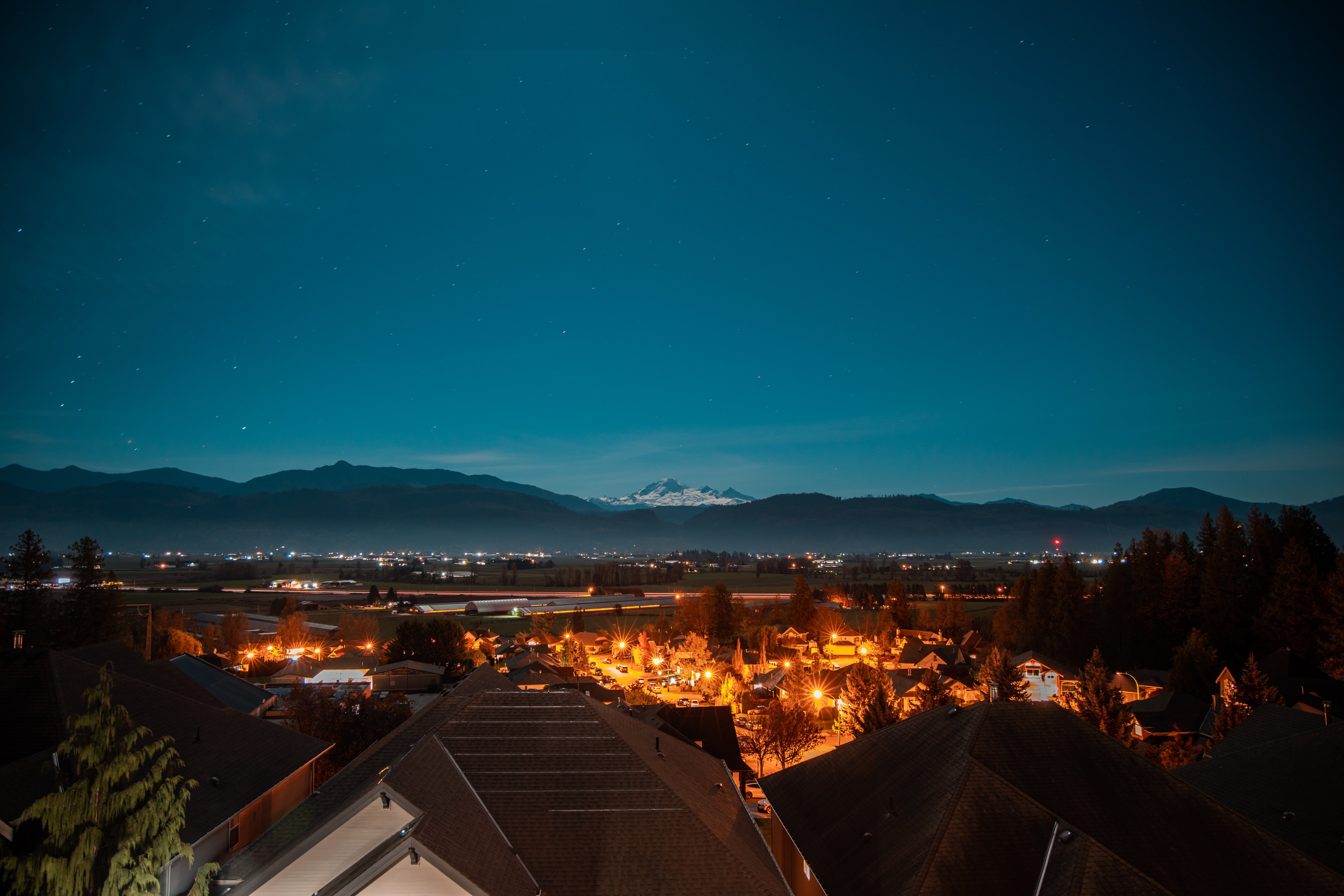 Stunning Town Vista: Snow-Capped Mountains Under a Starry Sky