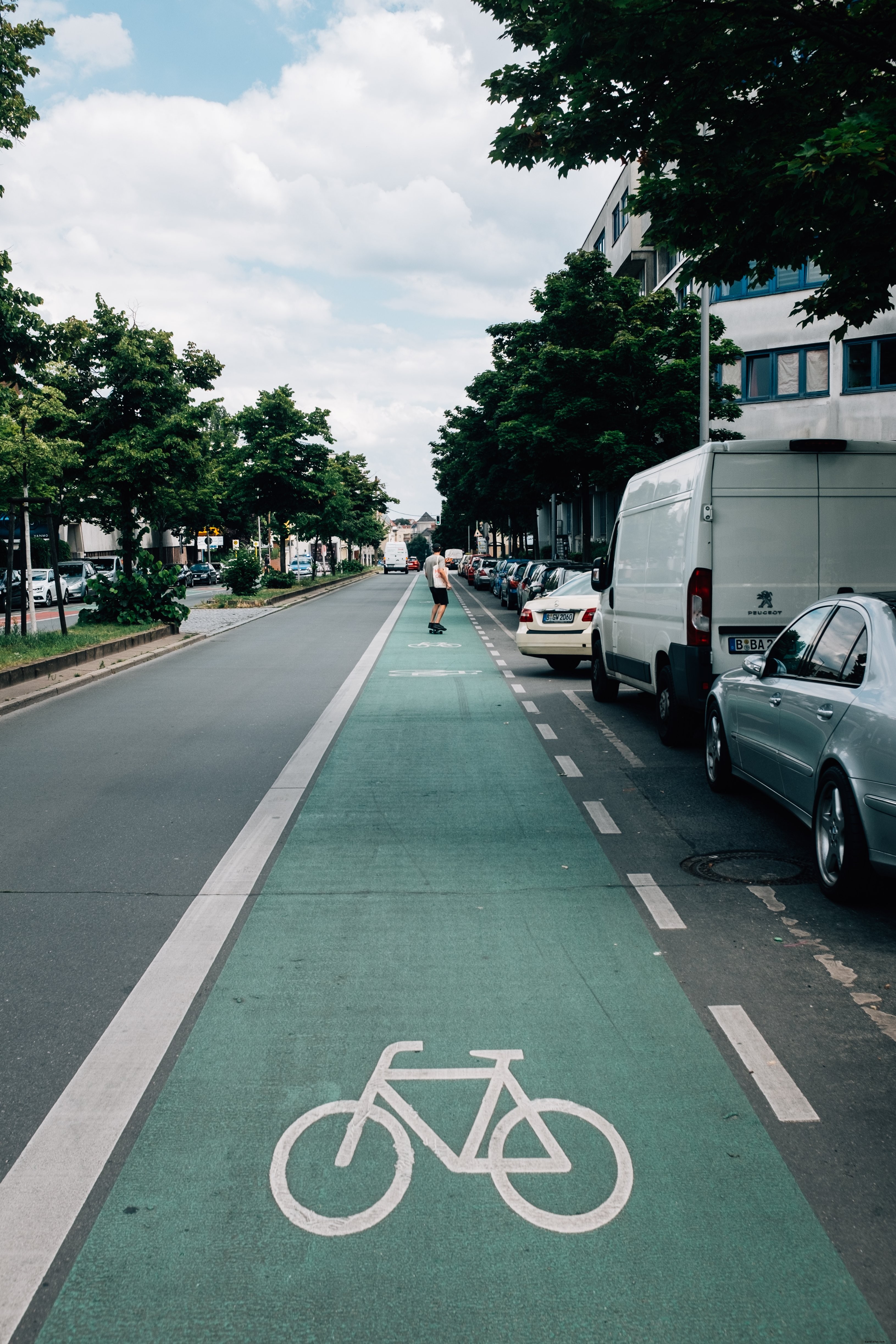 Vibrant Photo: Skateboarder Cruising Bike Lane on Sunny Day