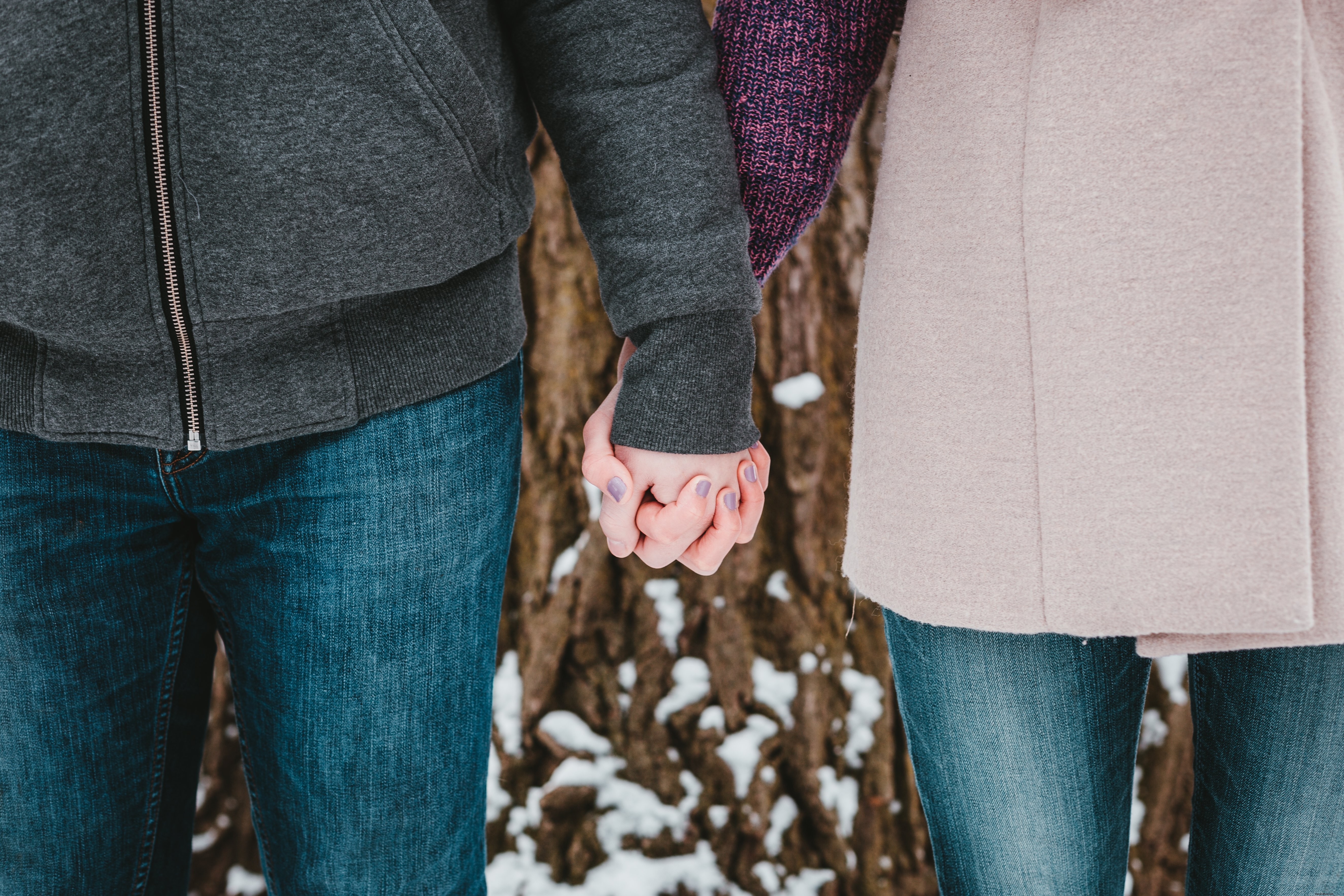 Romantic Winter Photo: Couple Holding Hands by Snow-Covered Tree