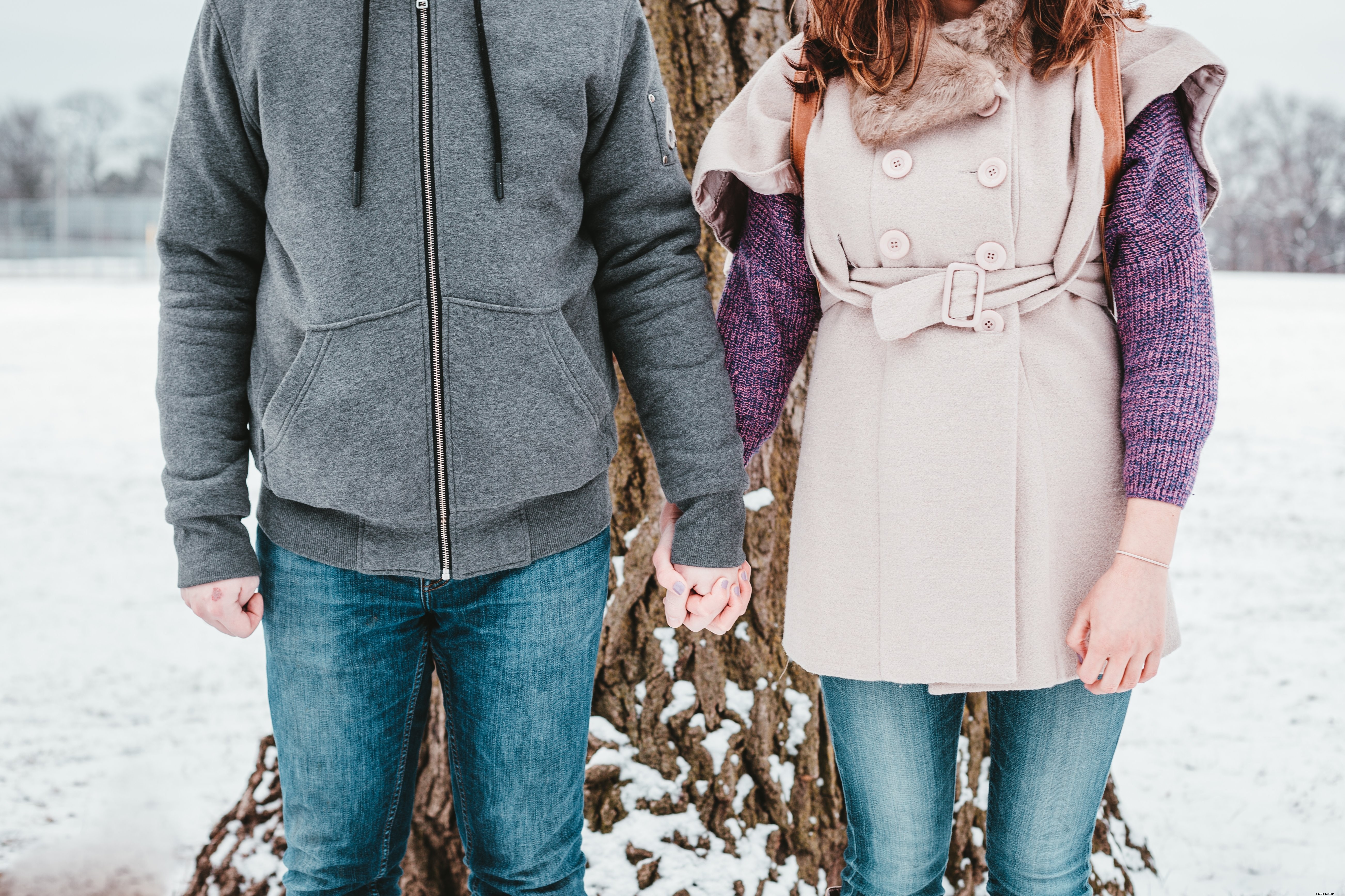 Stunning Winter Photo: Couple Braving the Cold by a Majestic Tall Tree