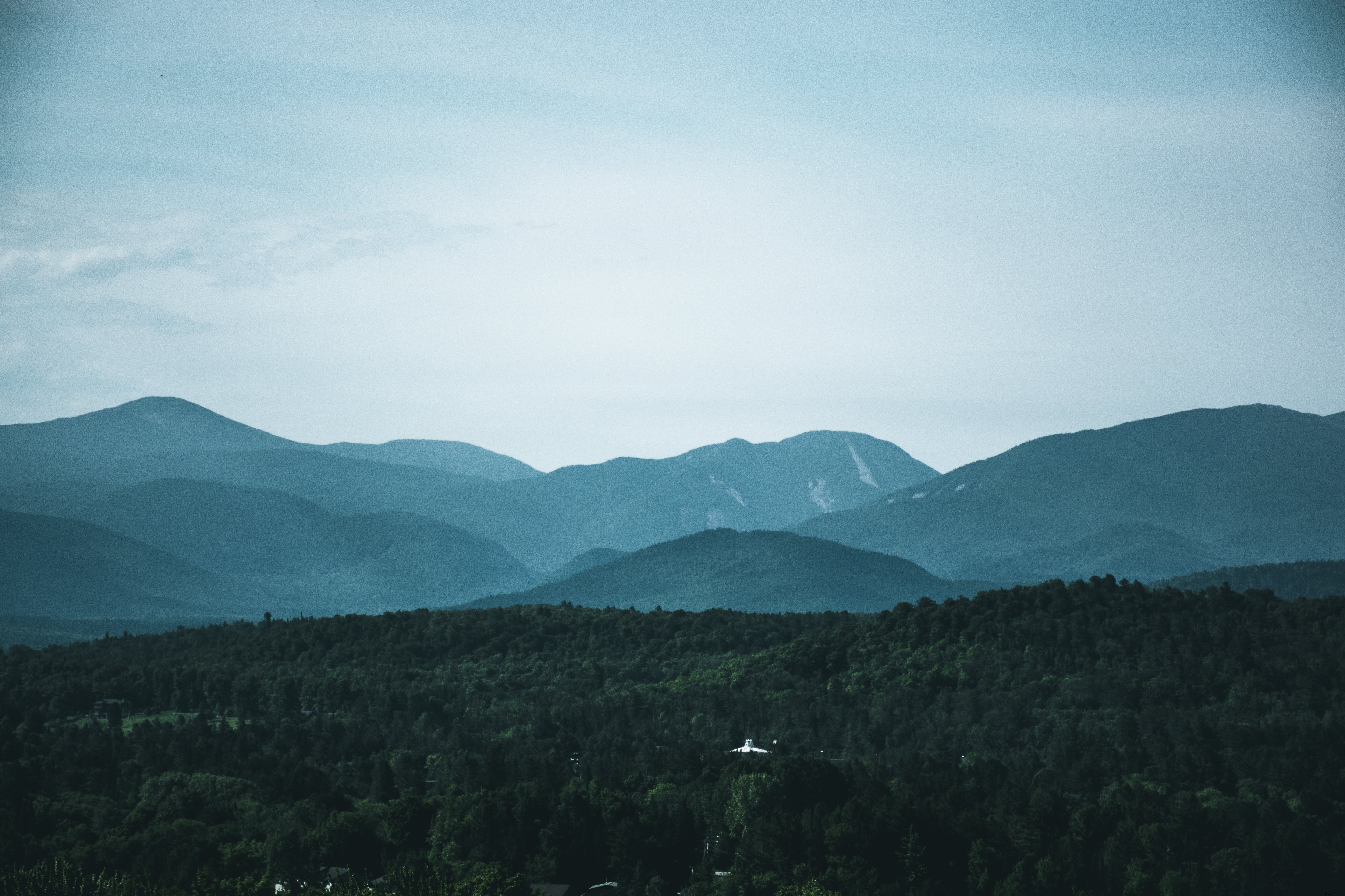 Stunning Landscape Photo: Rolling Hills Against Vibrant Blue Sky with Charming White Building