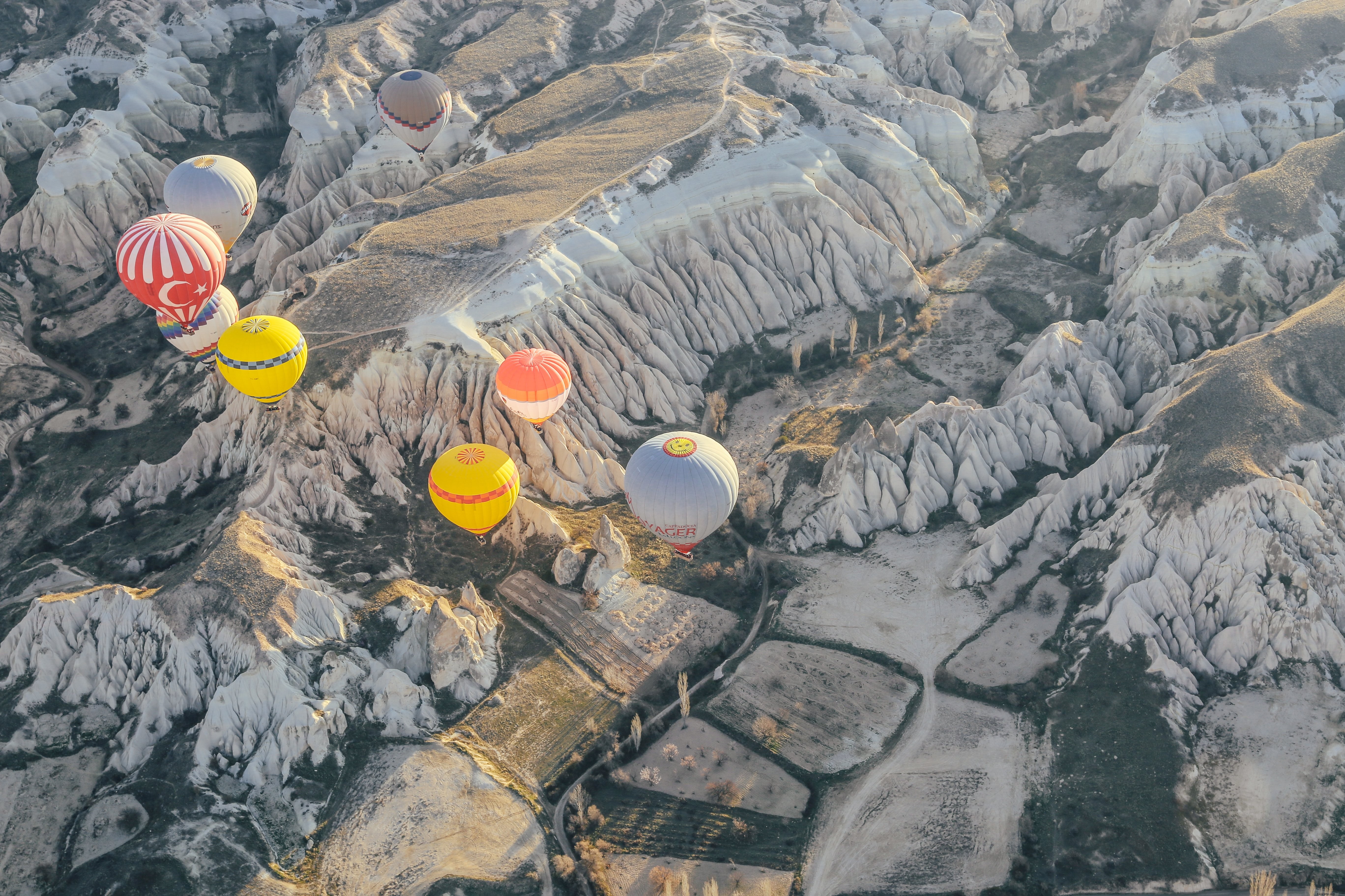 Stunning Hot Air Balloons Drifting Over Dramatic Rocky Landscape