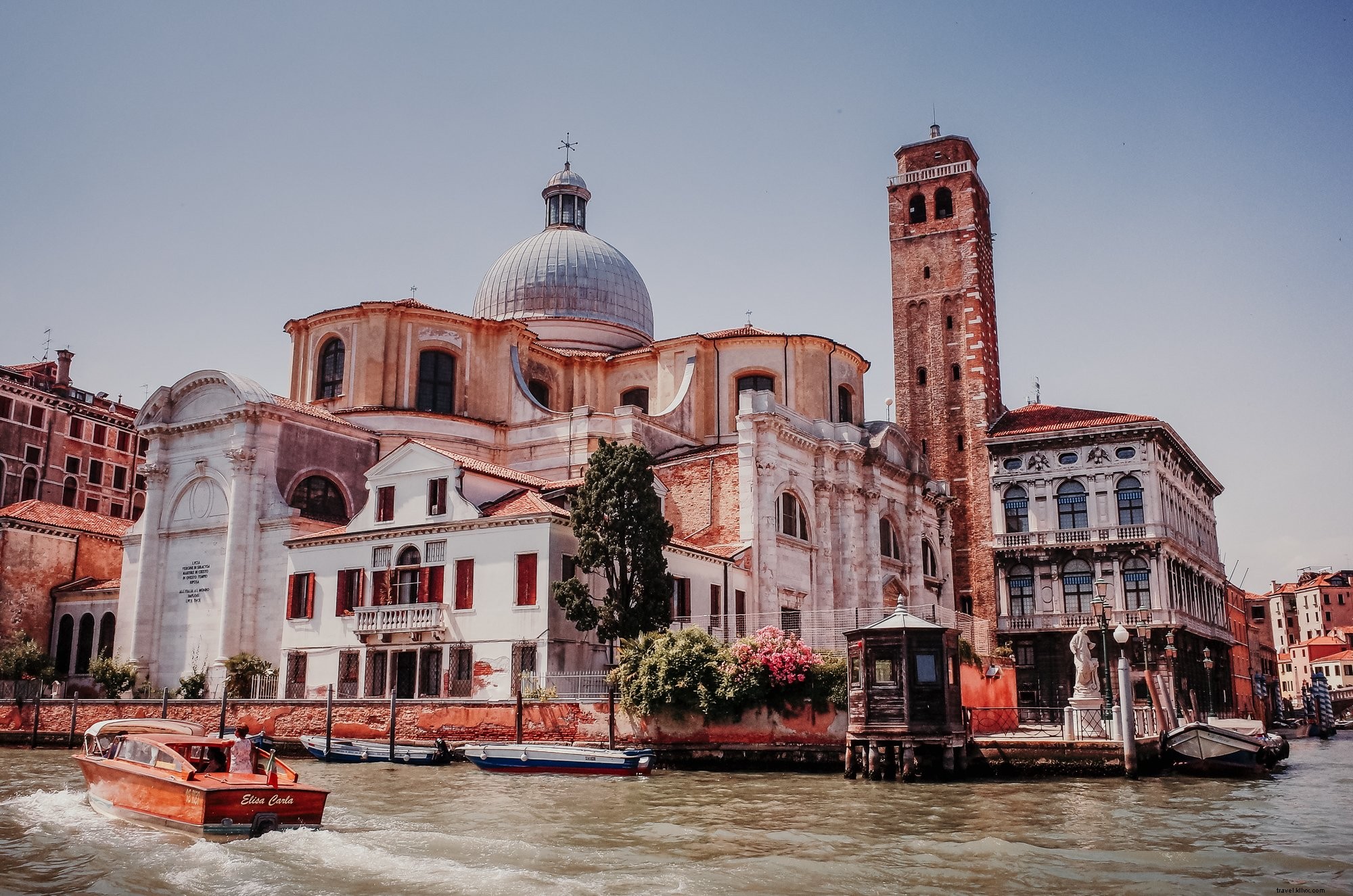 Stunning Photo: Tall White Skyscraper with Rust-Colored Waters in Foreground