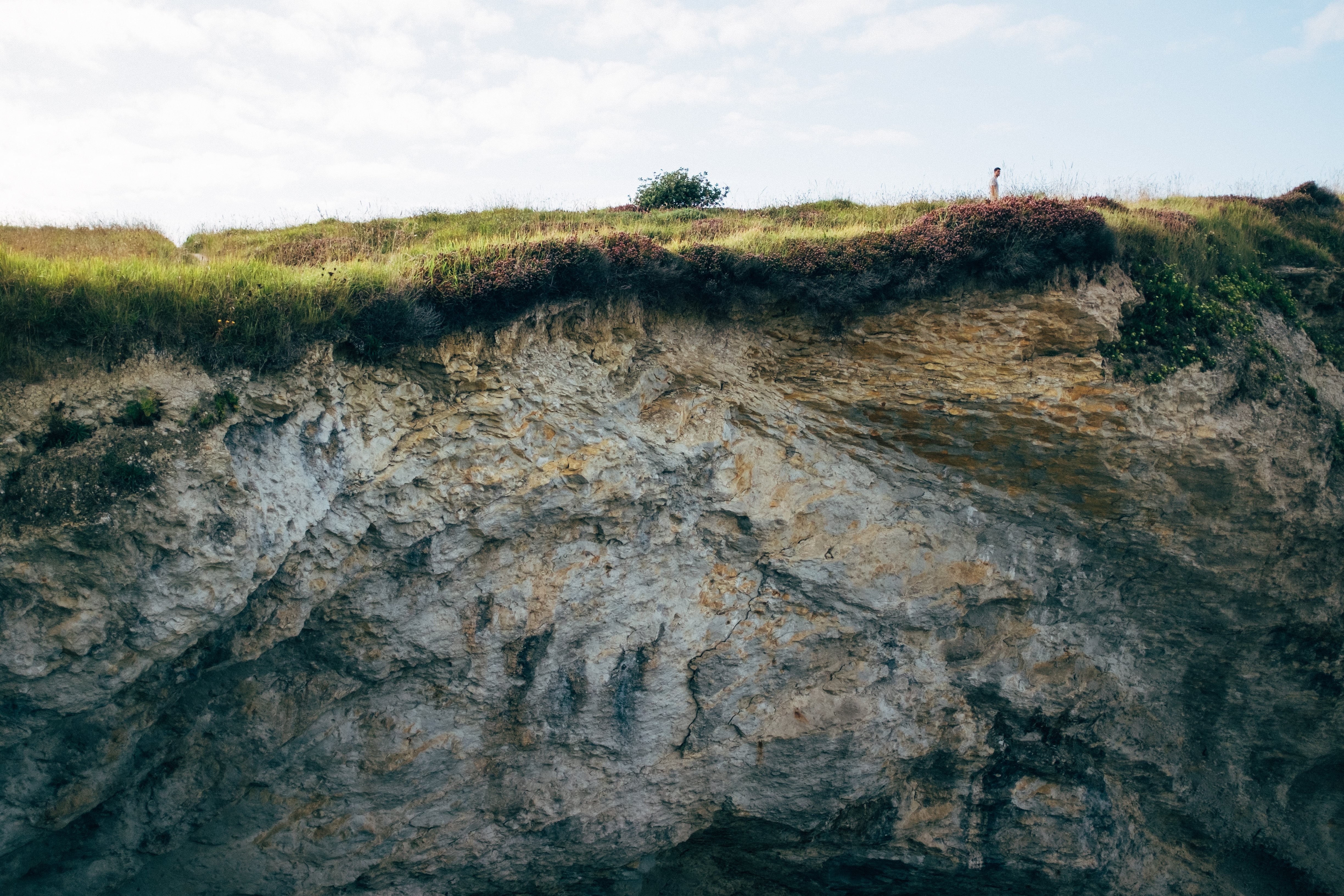 Lone Hiker on Cliff Hilltop: Stunning Landscape Photo